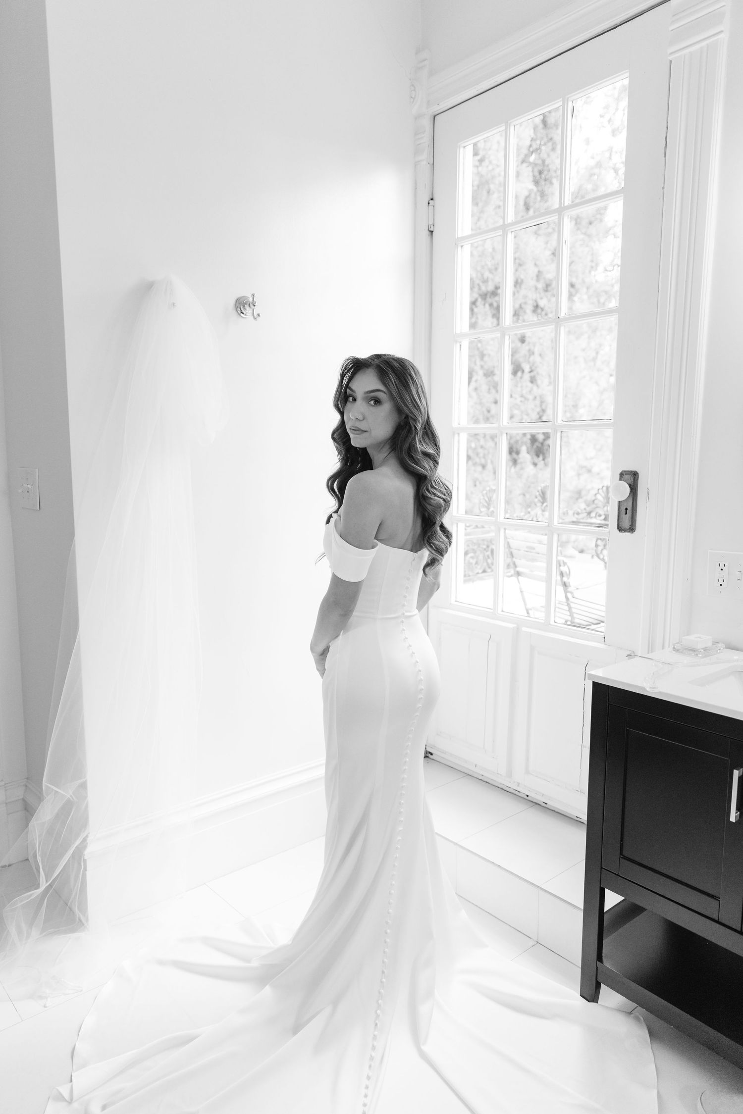 A series of ethereal black and white photographs showing a person in white clothing posing against bright windows.