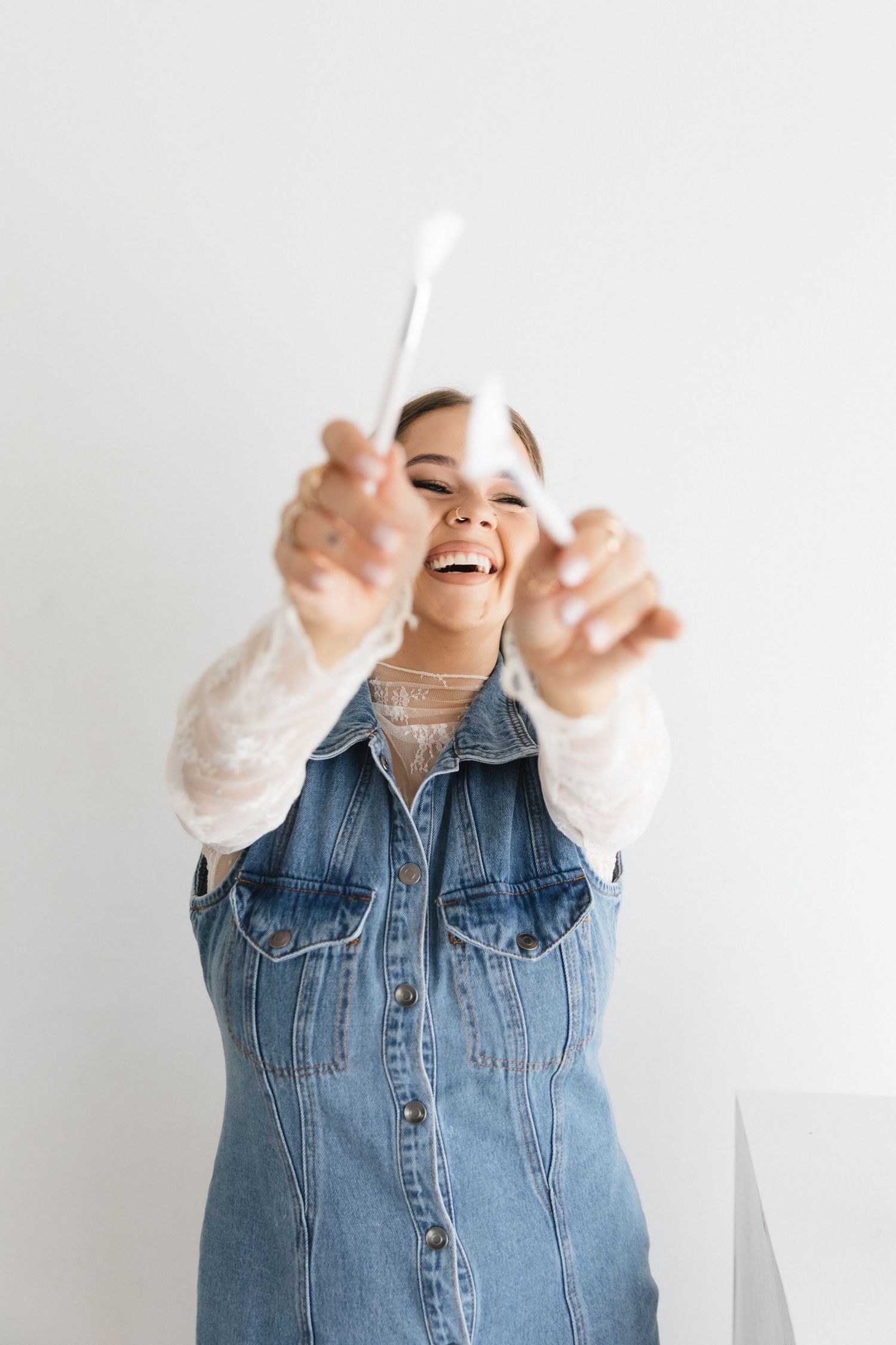 A sequence of four joyful expressions showing someone wearing a denim jacket against a white background.