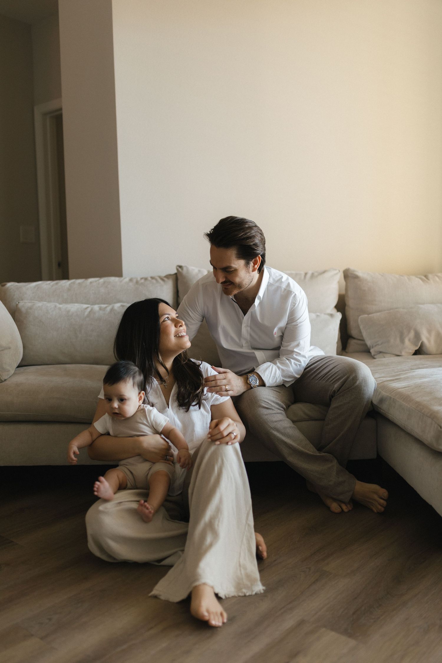 Family members spending quality time together on a cozy living room floor with white sofa in the background.