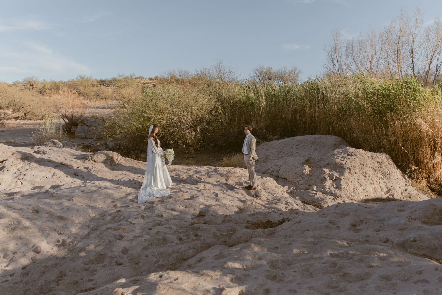 A series of photos showing a couple in white wedding attire posing on a sandy beach during sunset.