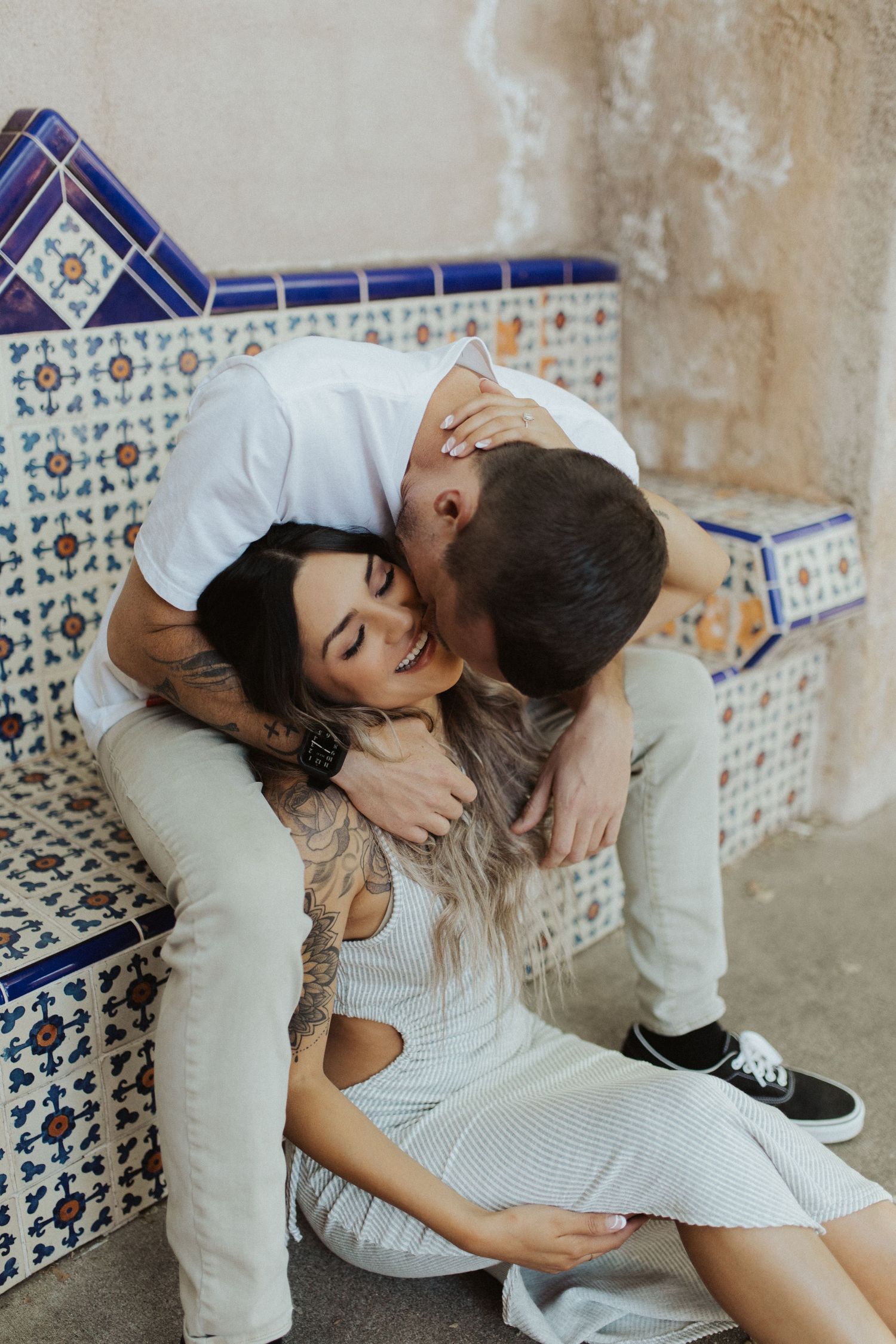 Romantic couple moment against decorative blue and white tiled wall background.