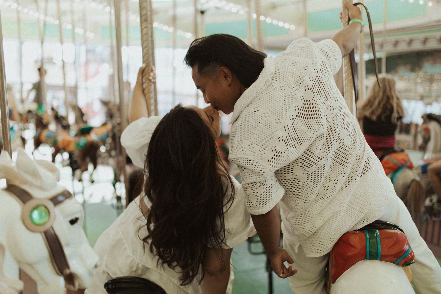 Couple enjoying romantic moment on carousel ride at carnival.