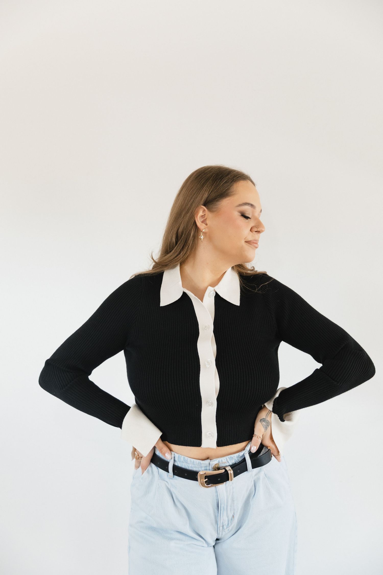 A person in a black crop top and light jeans poses in a series of dynamic movements against a white background.