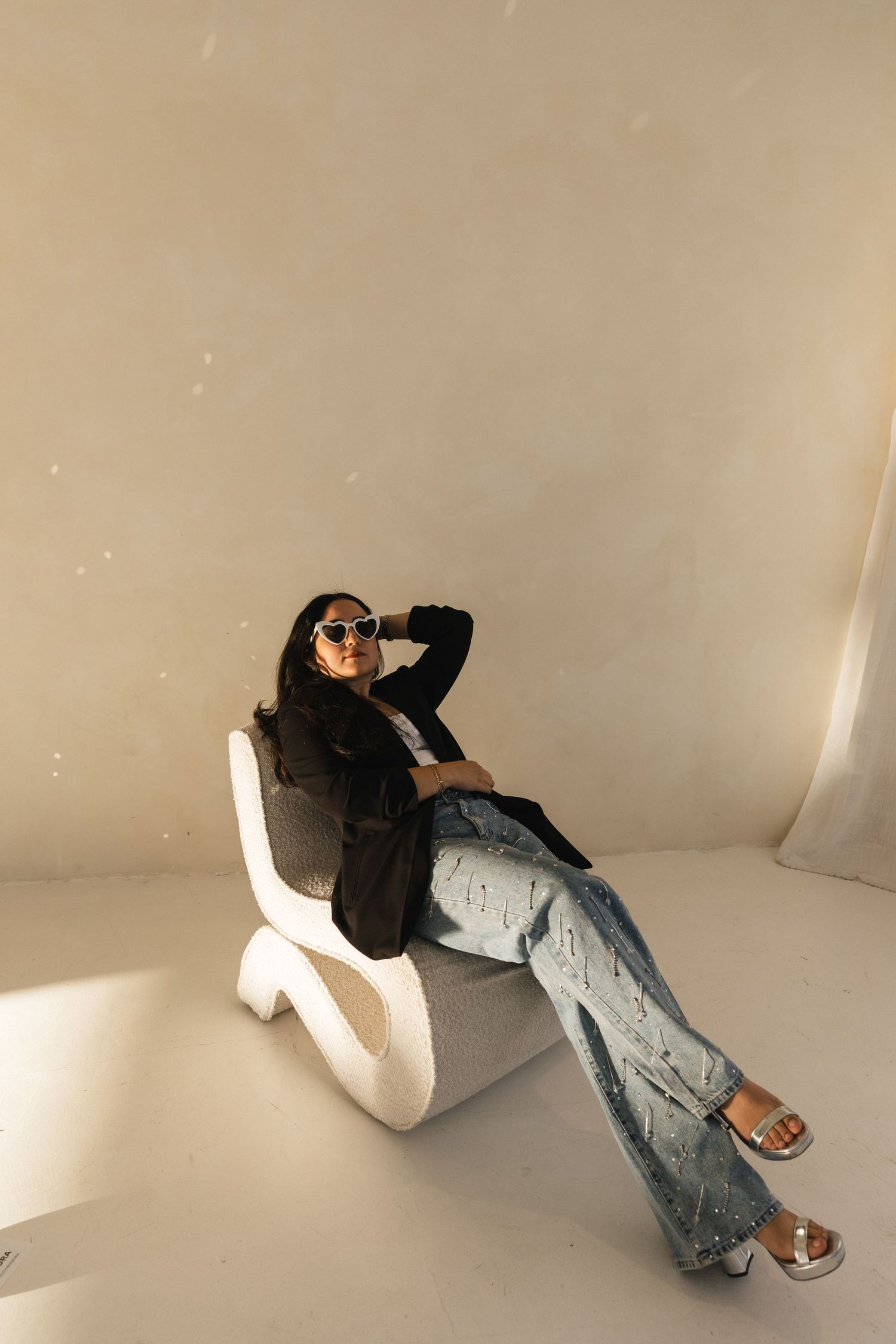 A sequence of images showing someone lying on a white floor wearing jeans and white shoes, captured from different angles.