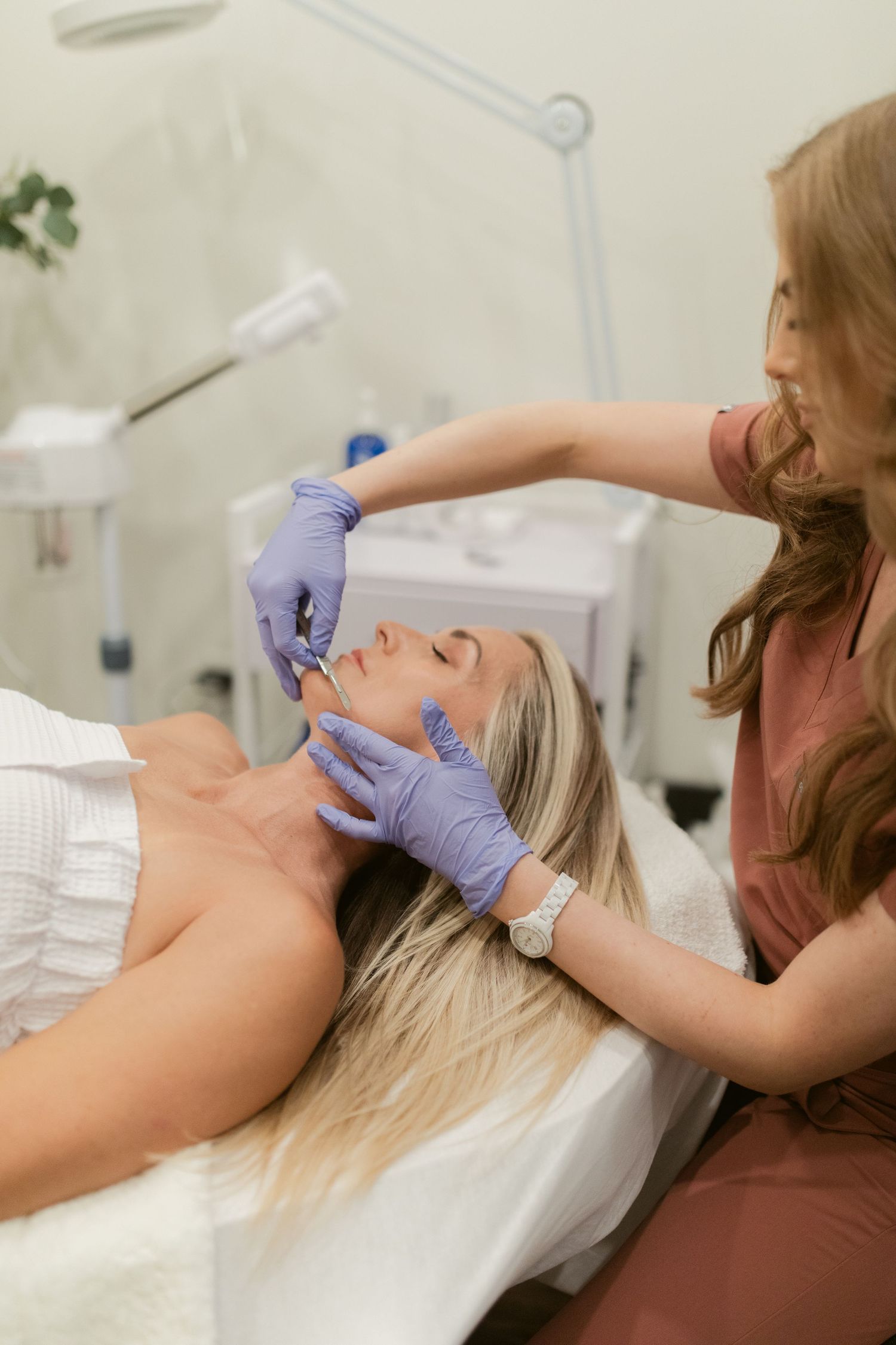 A professional beauty treatment being performed in a bright medical spa setting.