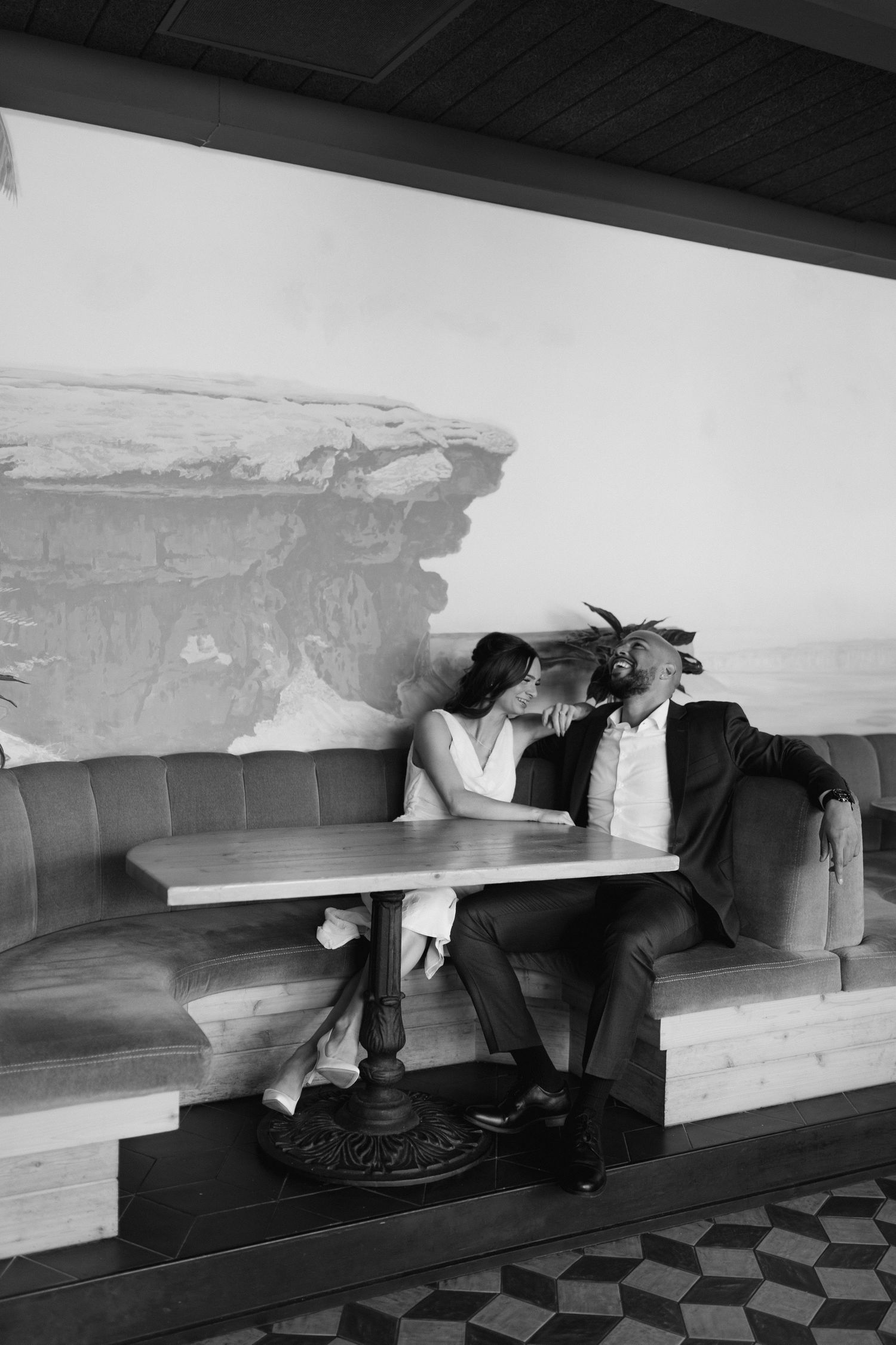 Black and white photo of couple sitting at vintage diner booth.