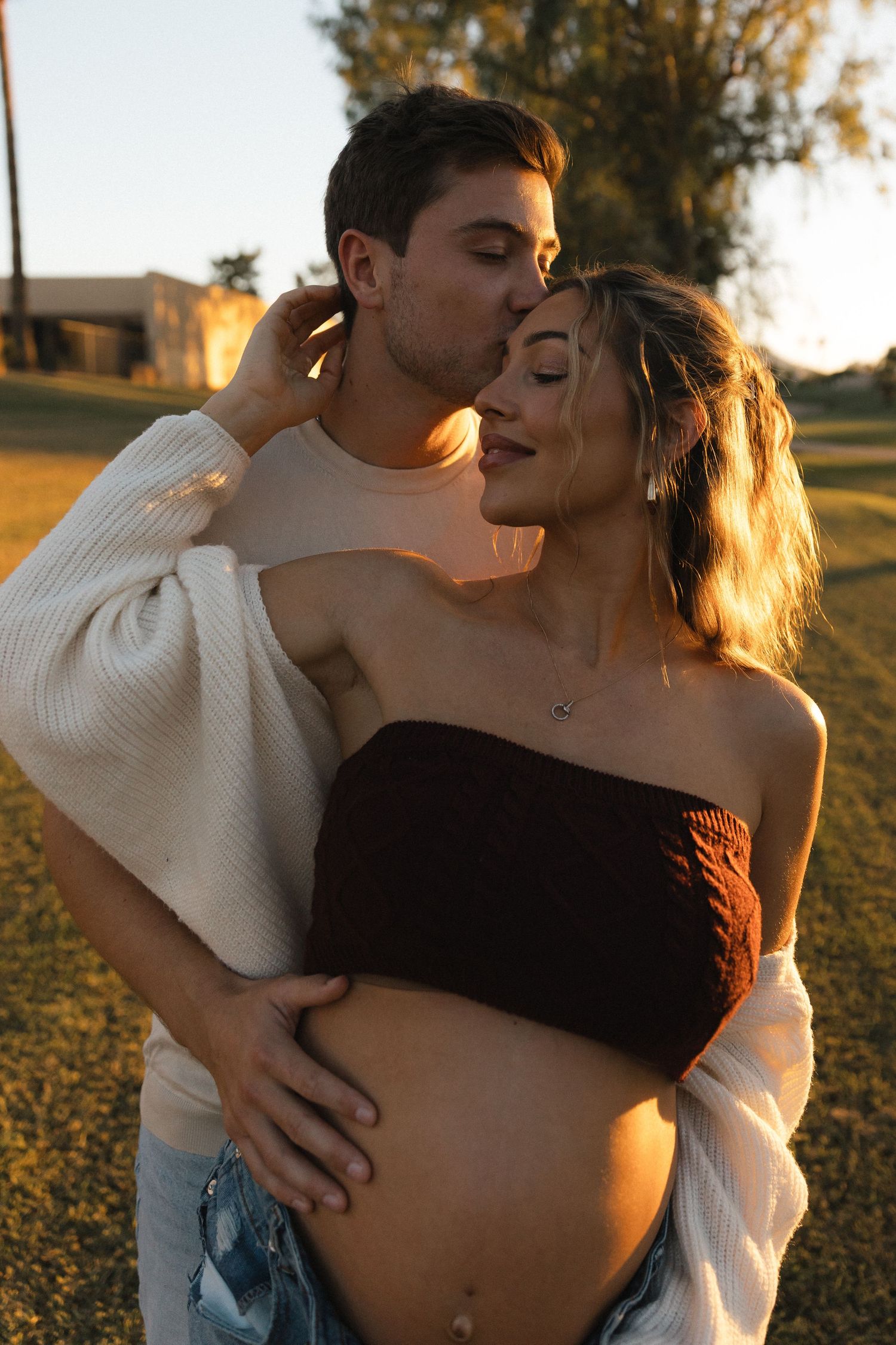 A romantic couple embraces in a sunlit field at golden hour, creating a series of intimate moments.
