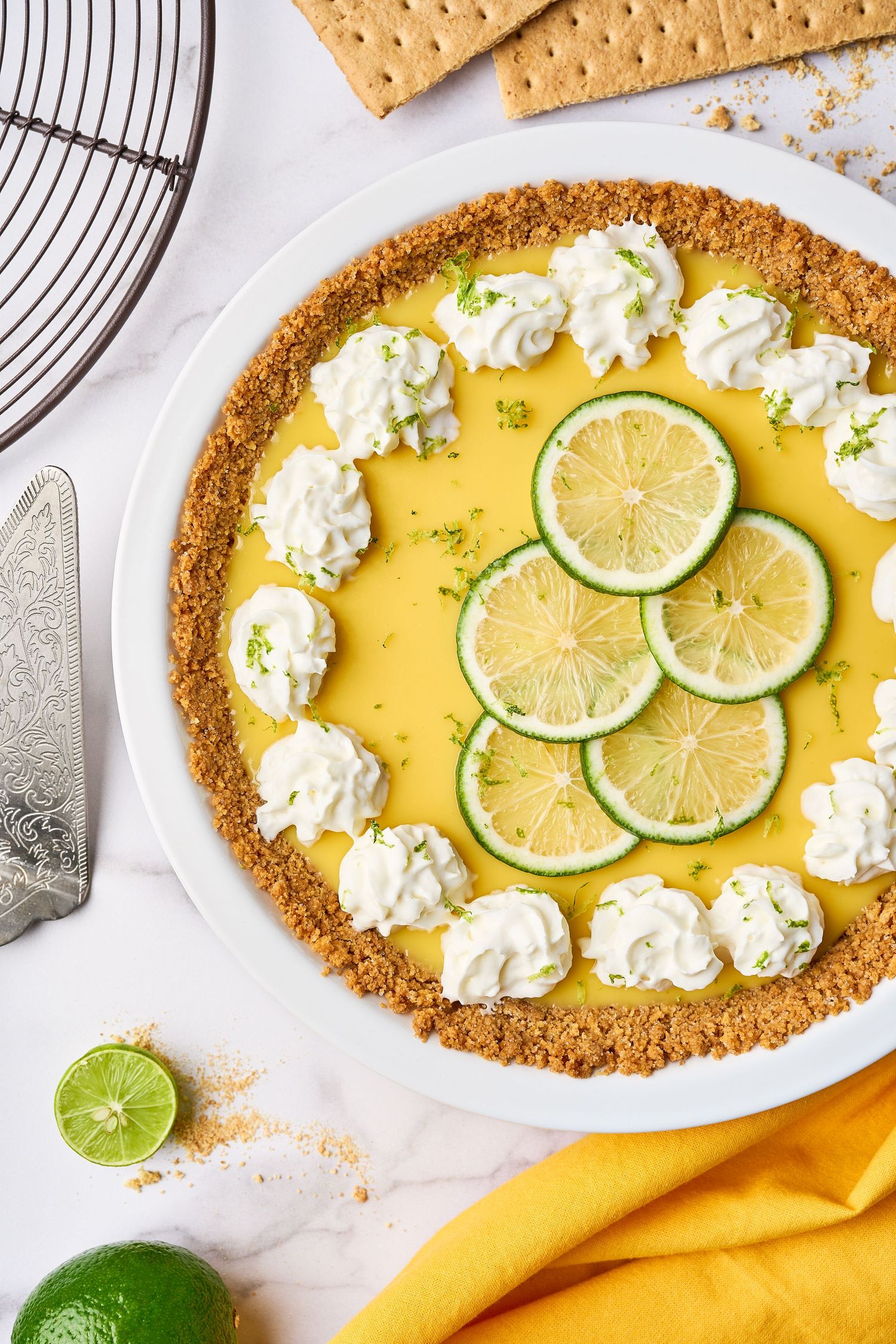 Step by step process of making key lime pie with graham cracker crust, lime filling, and whipped cream garnish.