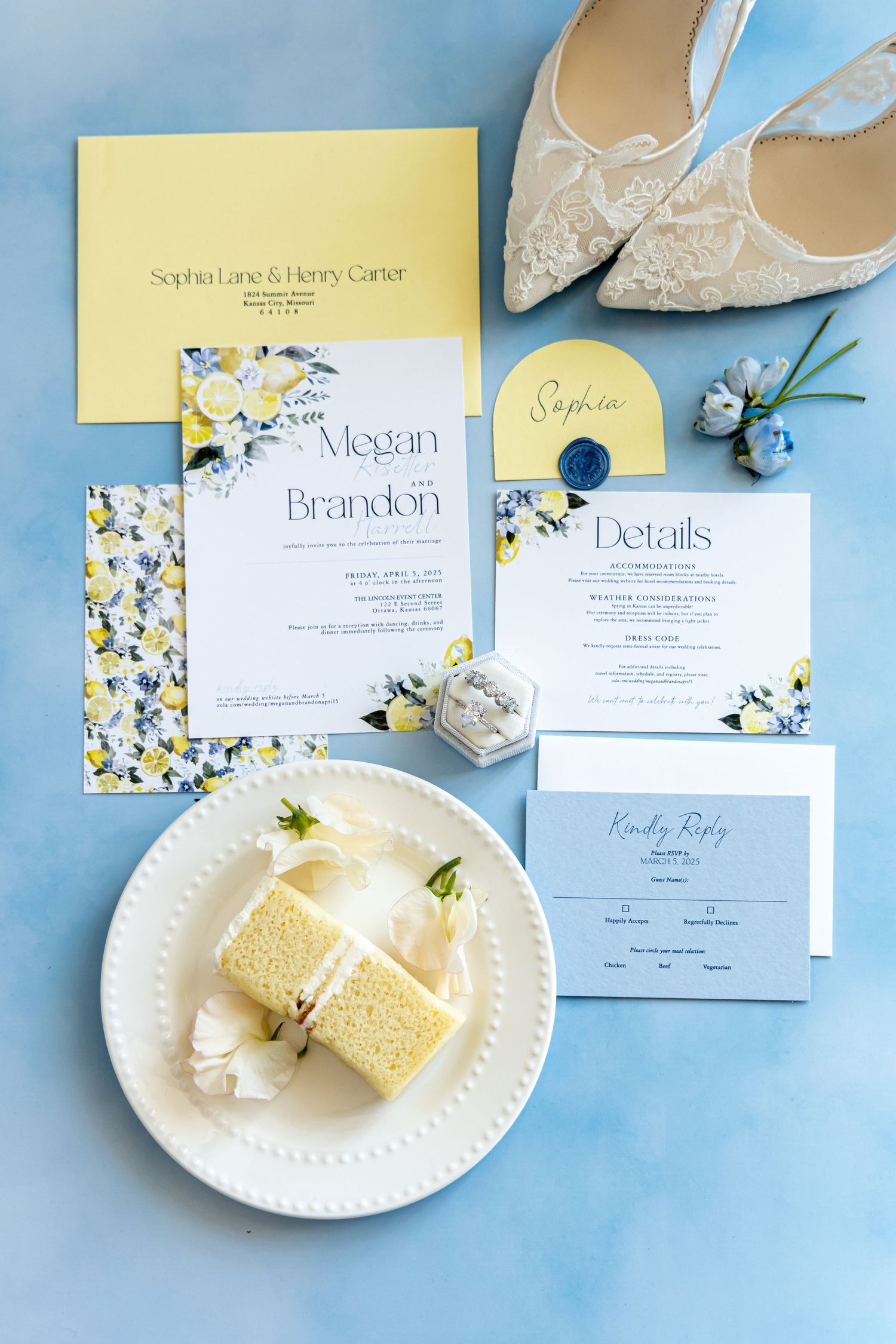 Wedding invitation suite in blue and yellow with lace shoes and cake slice on light blue background.
