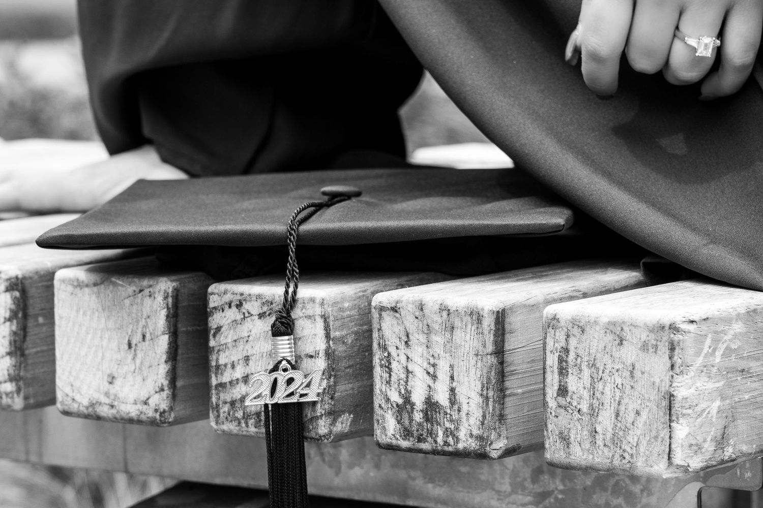 Close-up detail of a black leather item resting on rough stone blocks in black and white.