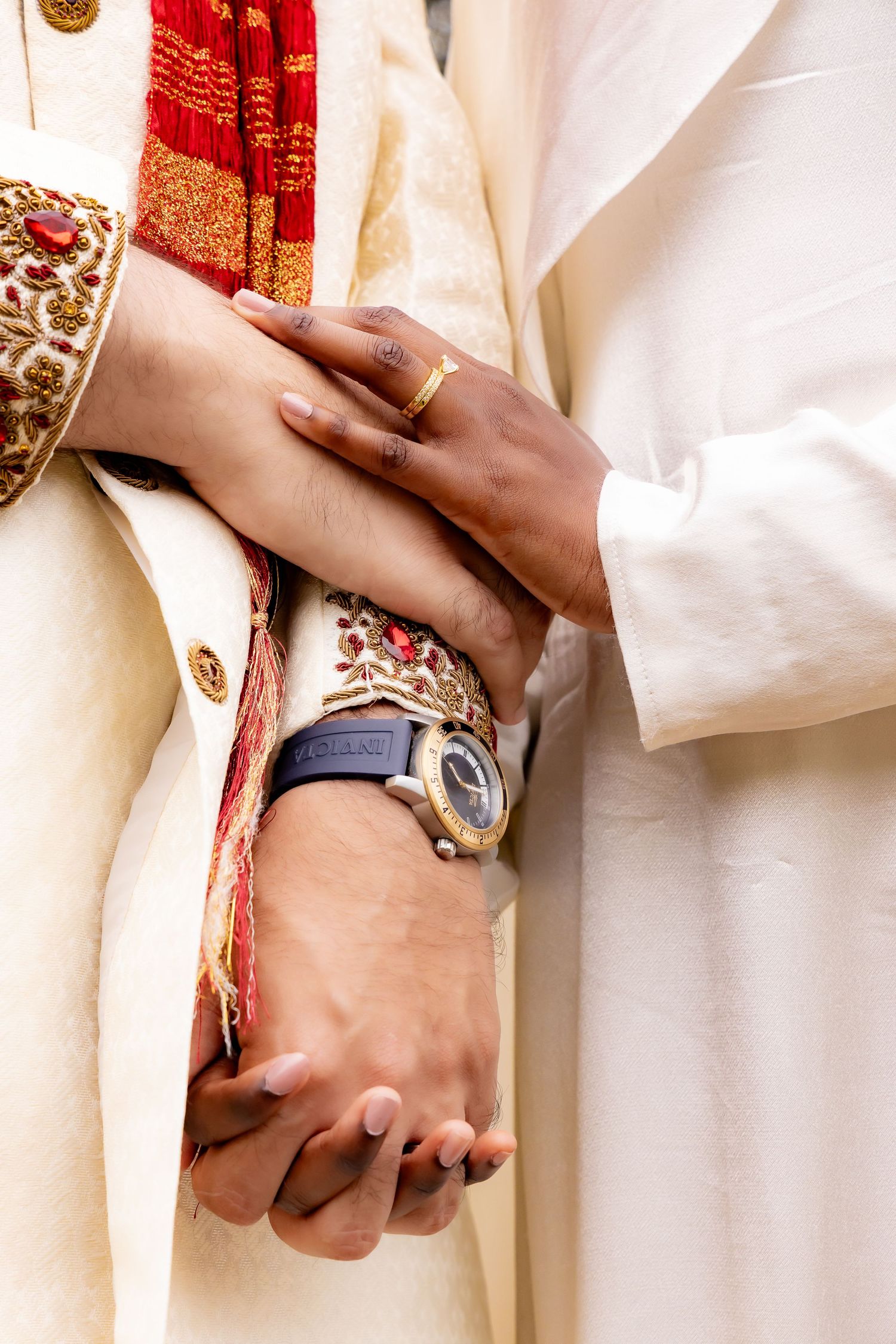 Close up of hands wearing traditional jewelry and rings with red and white cultural wedding attire. | PHL, PA Wedding Photographer | D