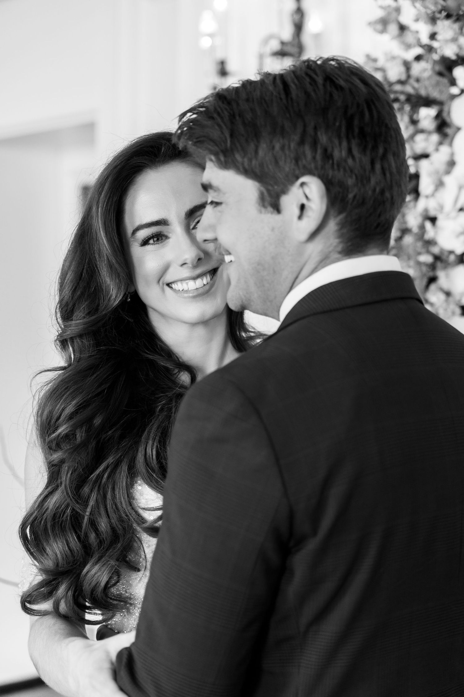 Black and white romantic portrait of a couple smiling together on their wedding day.
