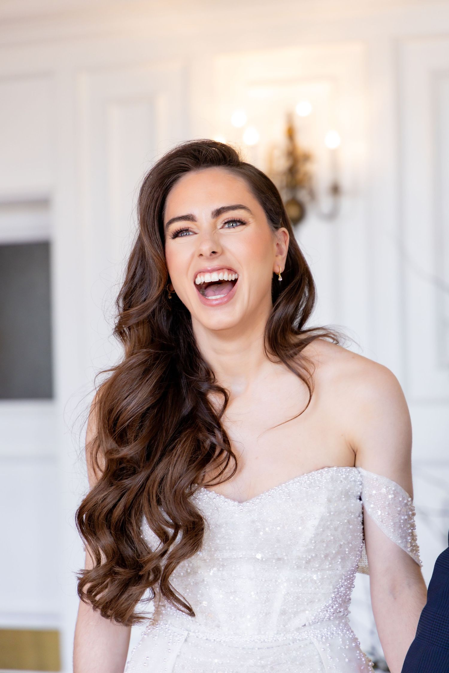 A joyful moment captured in an elegant white wedding dress against a bright interior.