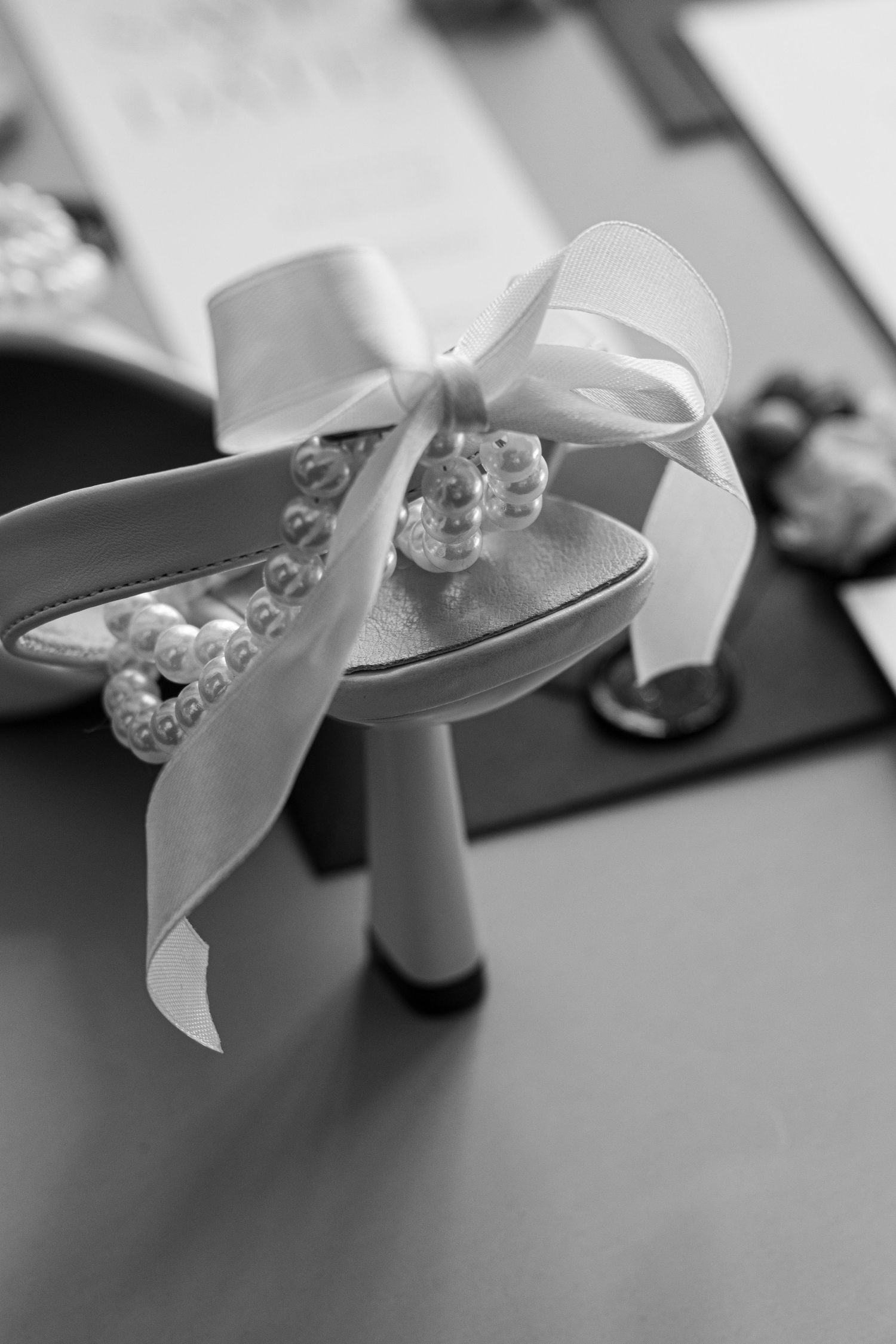 Close-up of a white satin bow with pearl embellishments in black and white.