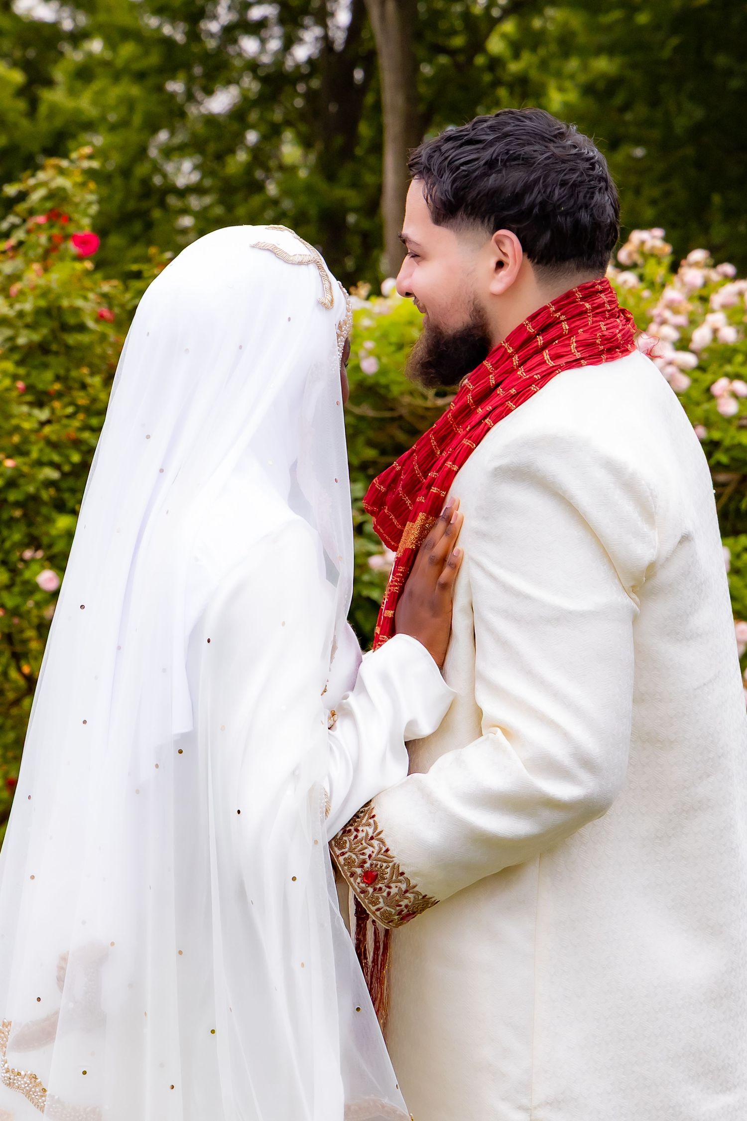 A couple in white wedding attire share an intimate moment in a garden setting with a sequence of progressive shots. | PHL, PA Wedding