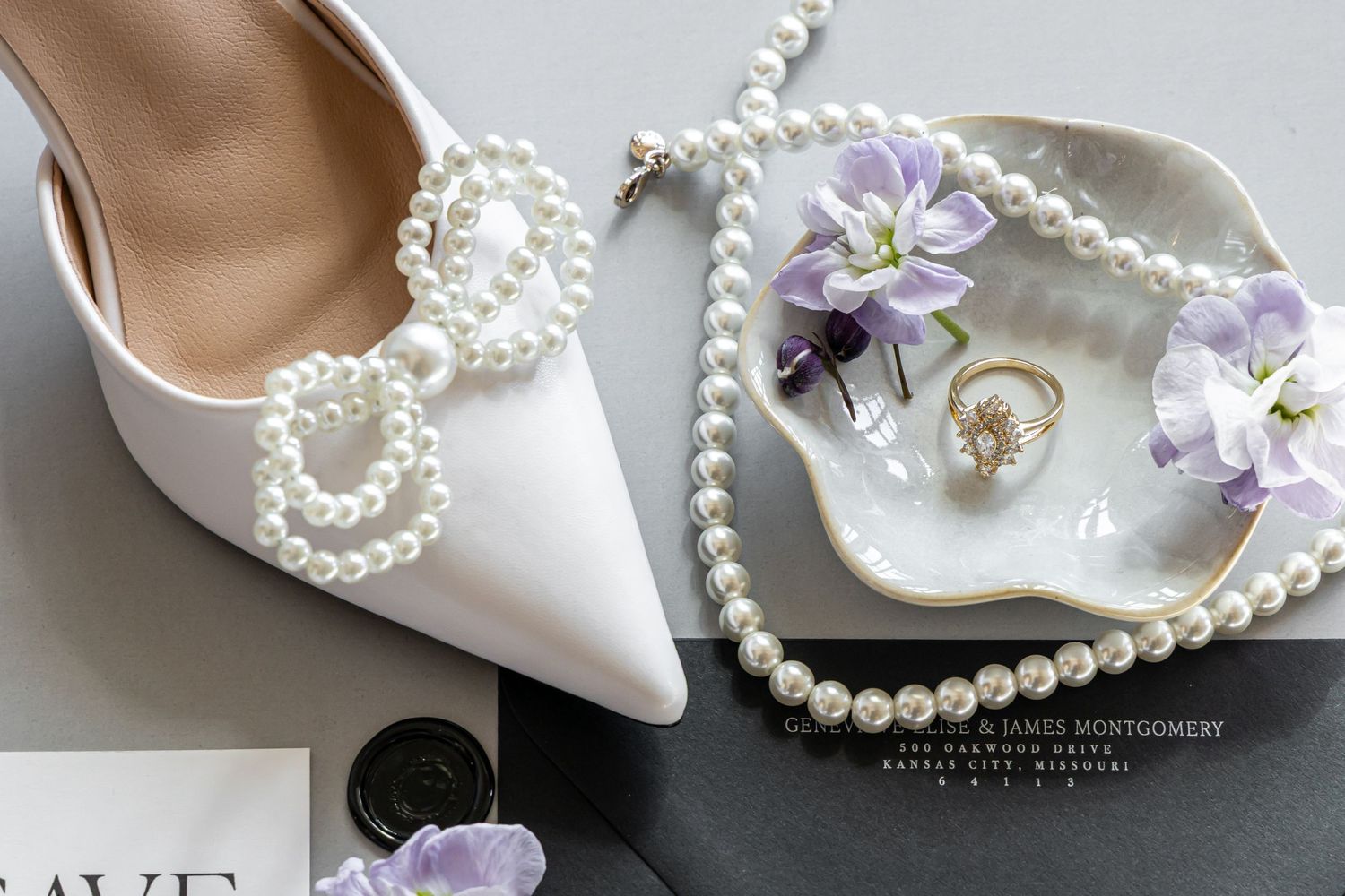Elegant white bridal shoe with pearl details and matching jewelry on a decorative dish.