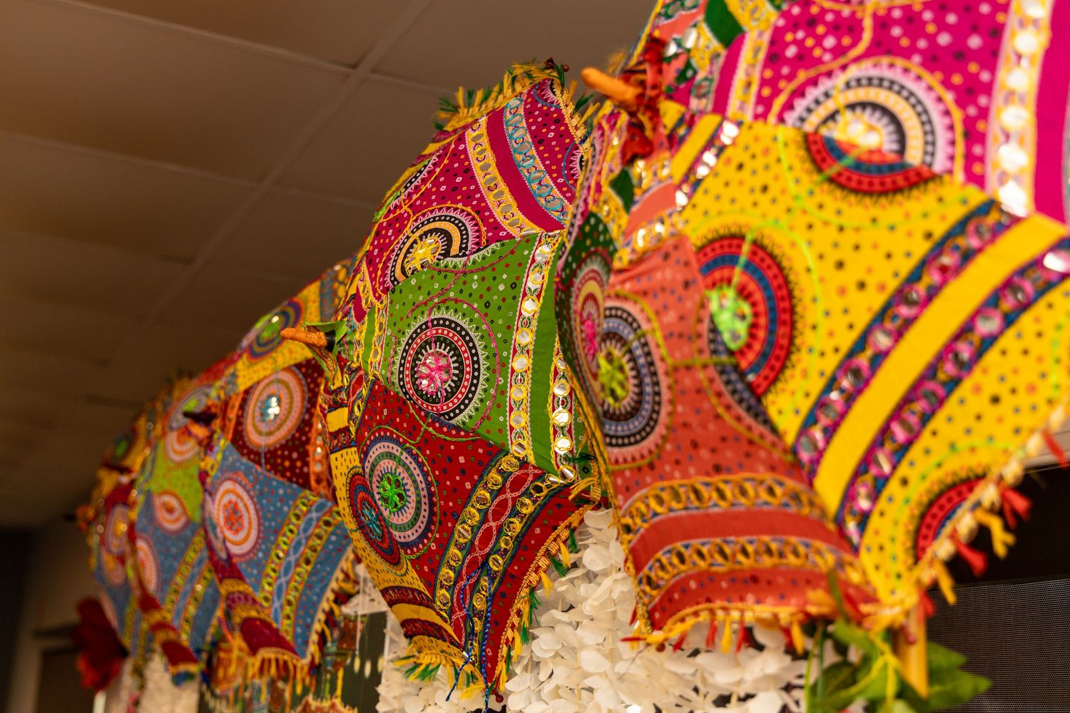 Colorful Desi umbrellas with intricate circular patterns and embellishments in vibrant yellow and red tones. Bengali Mehndi | | PHL, PA