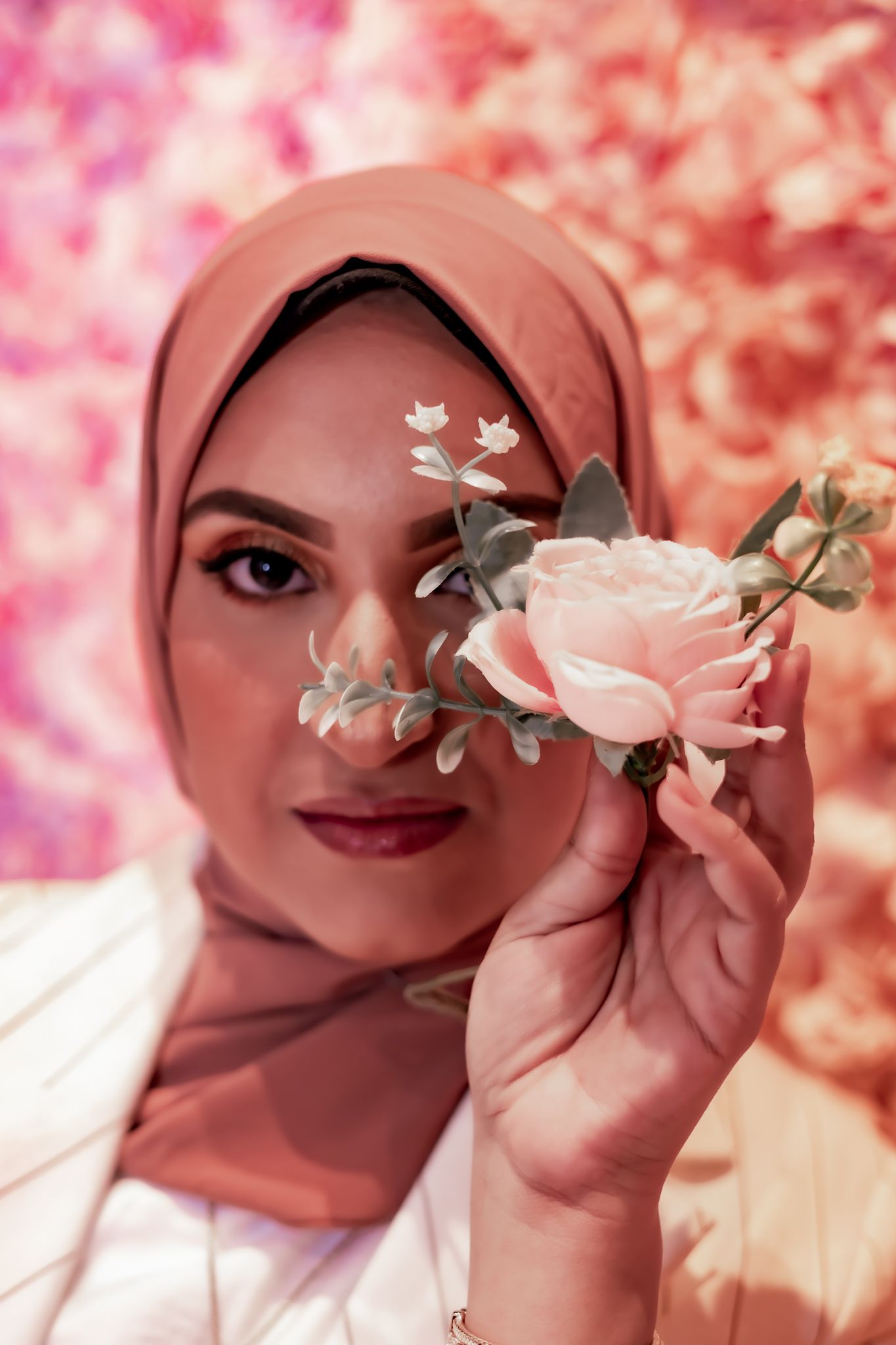 A delicate portrait featuring a pink rose against a rosy bokeh background with soft feminine styling.