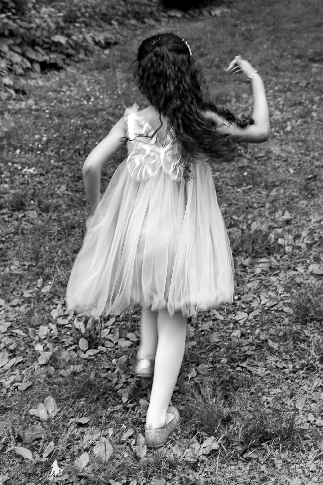Black and white photo of flowing dress movement in a natural outdoor setting.