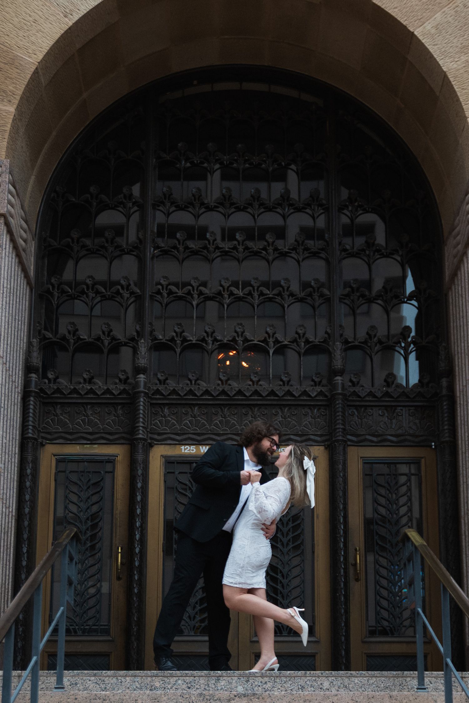 A couple shares a romantic kiss under an ornate stone archway in a sequence of progressive frames.
