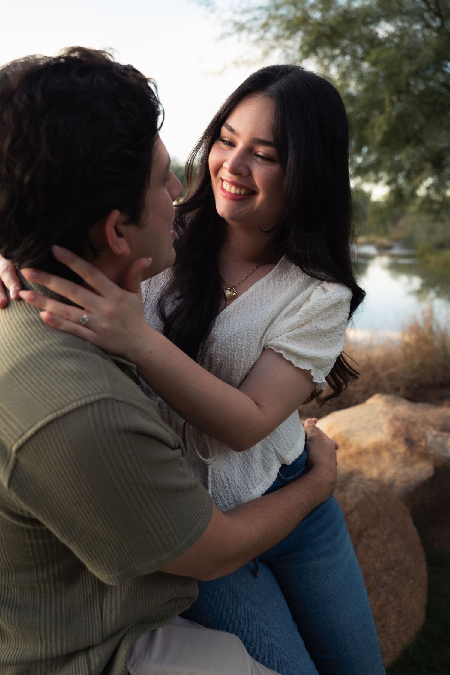 A romantic couple embraces outdoors in a series of candid moments against a natural background.