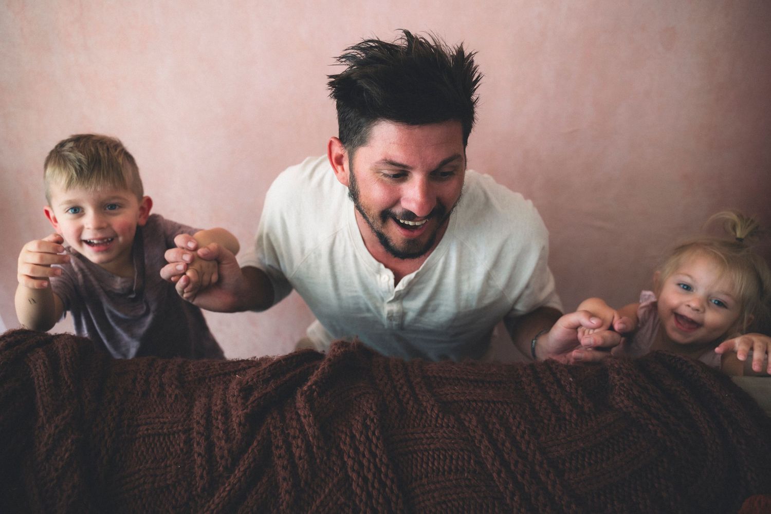 A loving pair shares playful moments with a young child in a sequence of candid photographs on a brown couch.