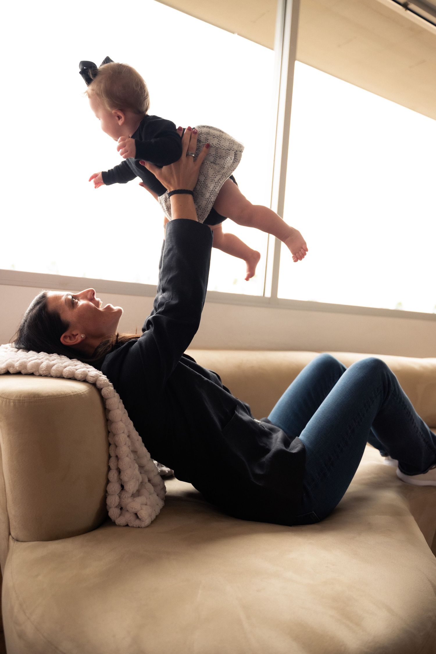 Parent and child play together on a beige couch in a series of four connected photos showing joyful interaction.
