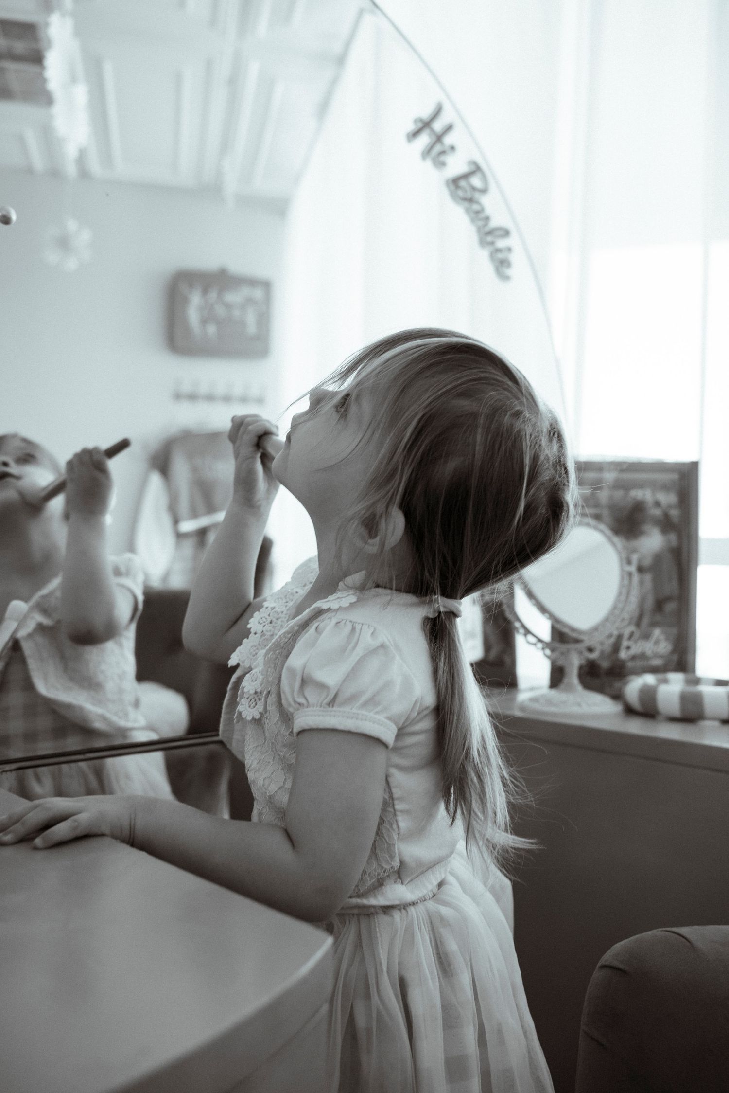 A young girl in a dress leans back in a retro-style diner booth.