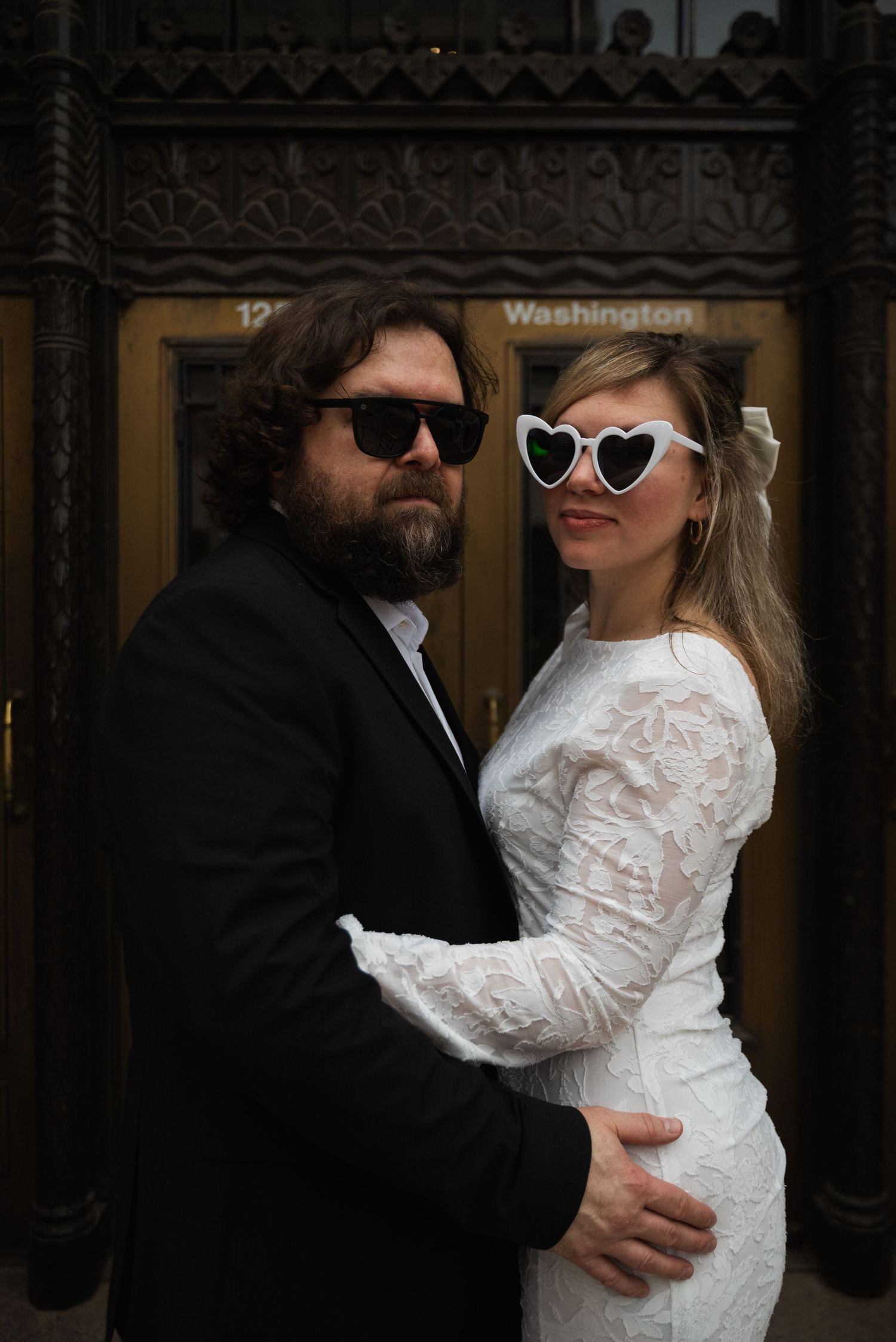 A couple in heart-shaped sunglasses and wedding attire share romantic moments in a sequence of candid shots.