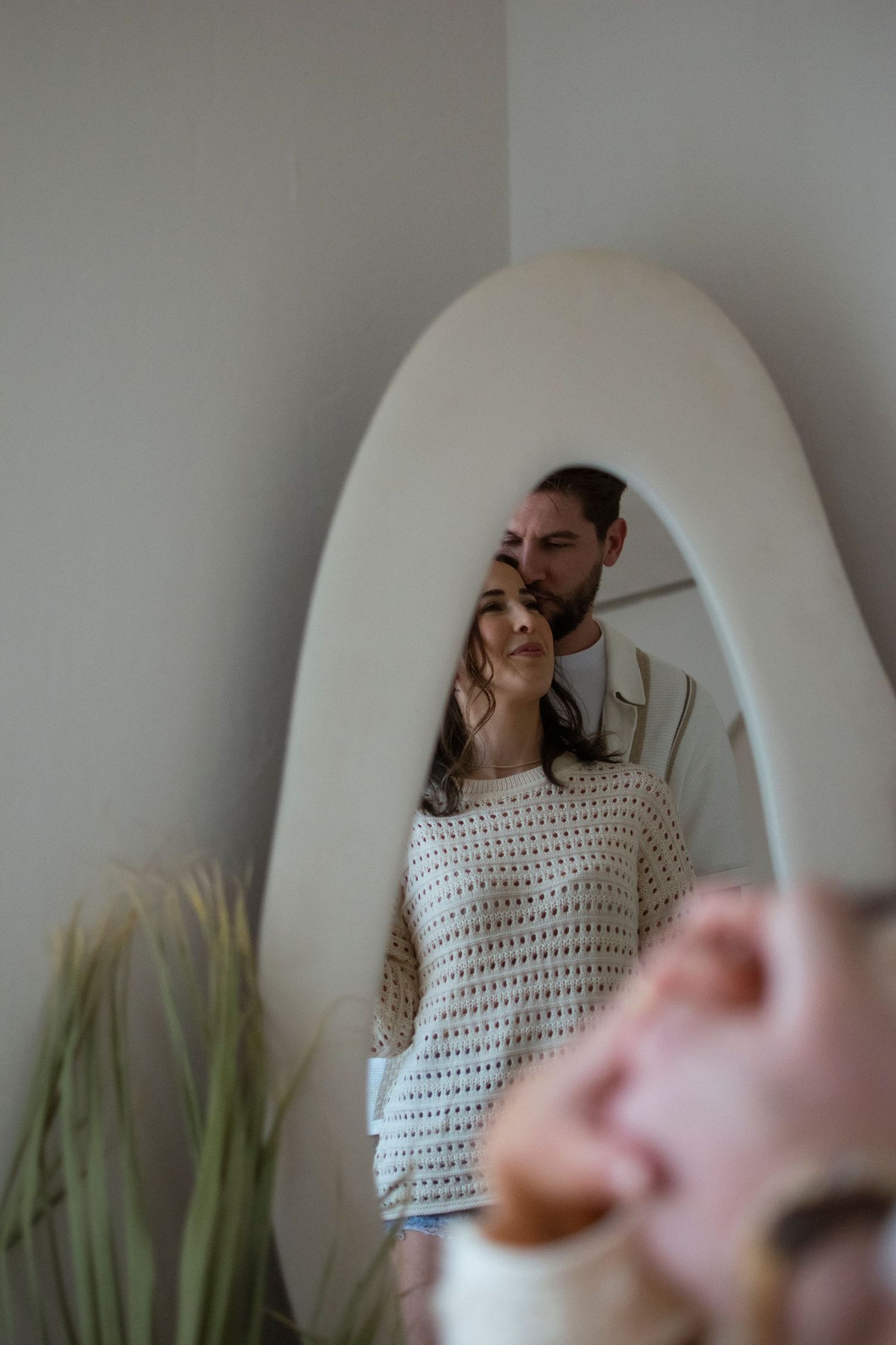 Series of playful self-portraits taken in mirror with white curved wall background.