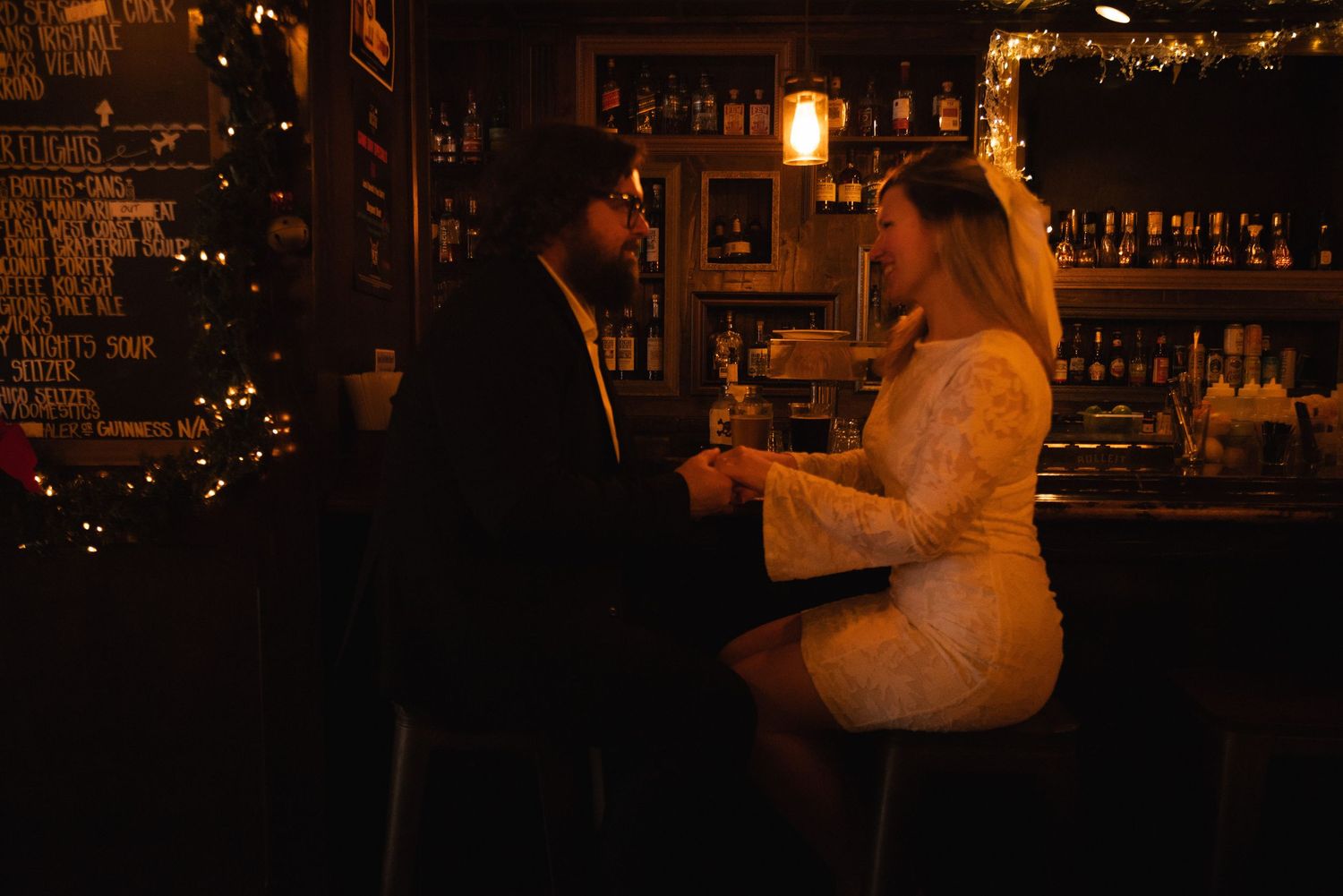 Seven sequential photos show someone performing a backflip at a dimly lit bar or restaurant setting.