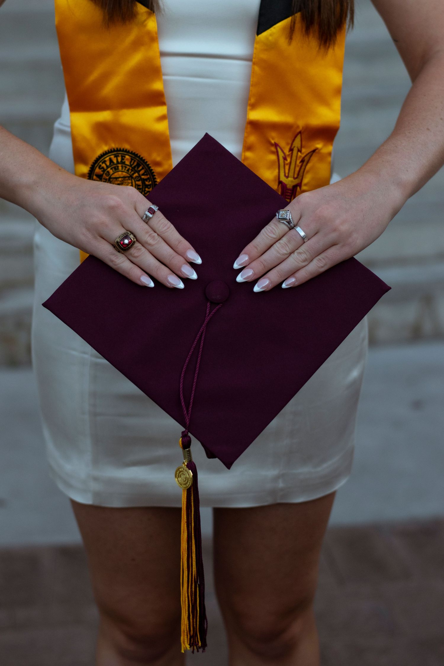 A graduate wearing a yellow top and khaki shorts holds a burgundy diploma folder in four sequential poses.