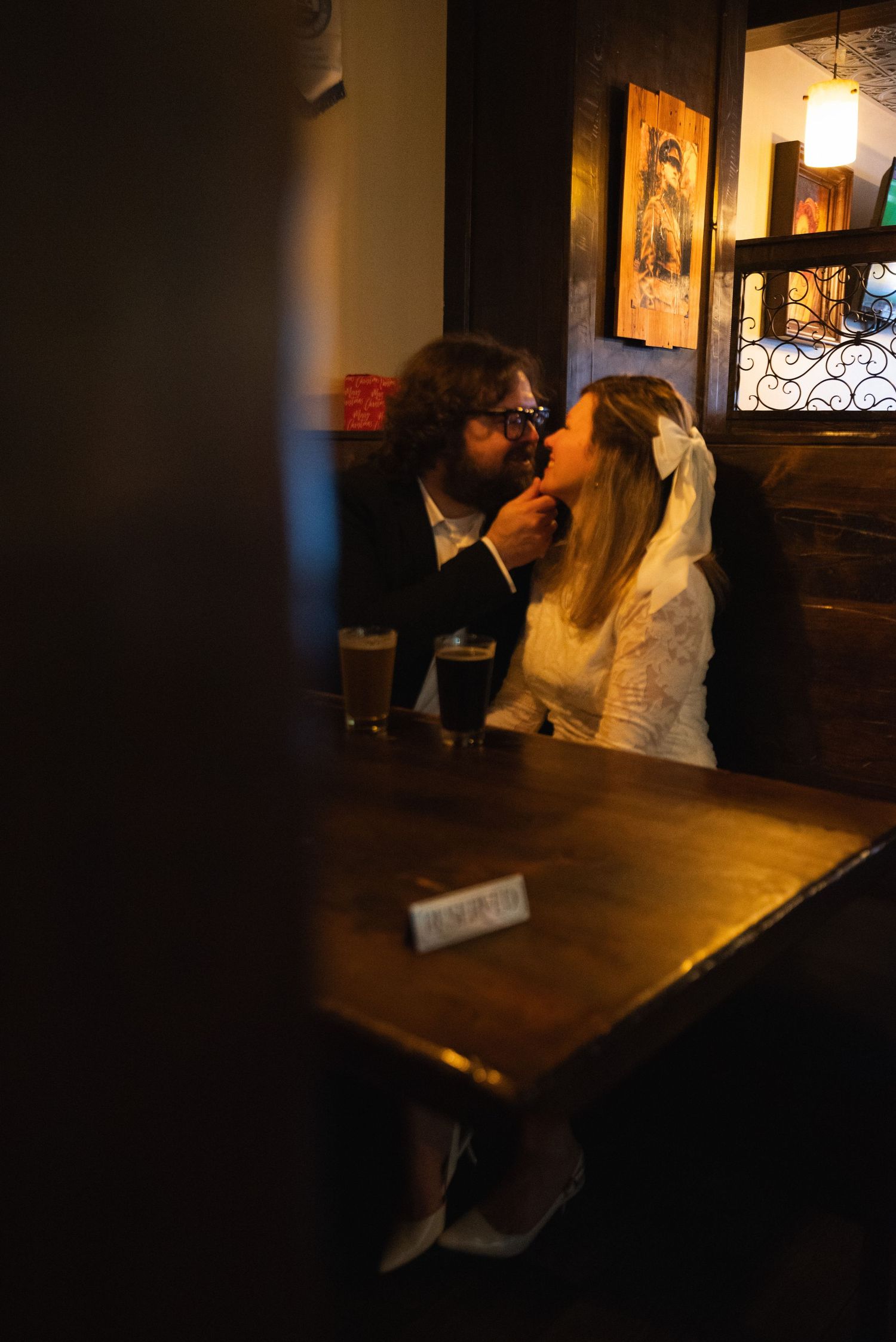People seated at a dark wooden table in a cozy pub atmosphere with ambient lighting.