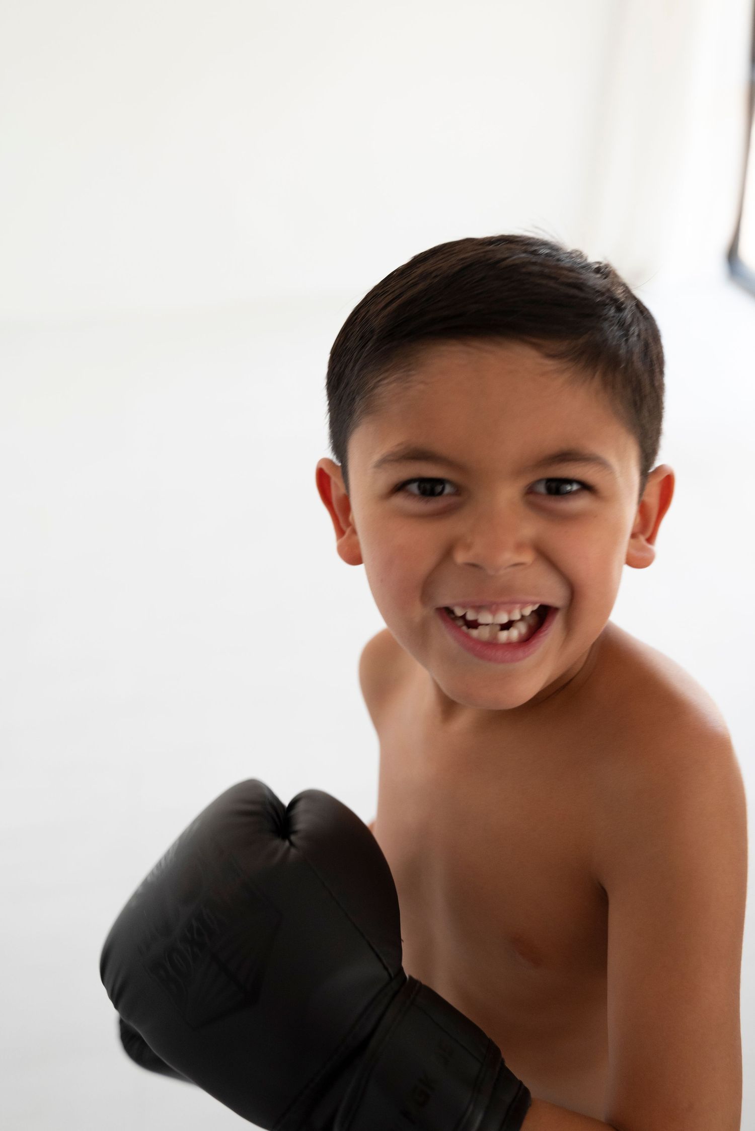 A smiling child with Boxing Day gloves training in fitness, creating an energetic and happy atmosphere.