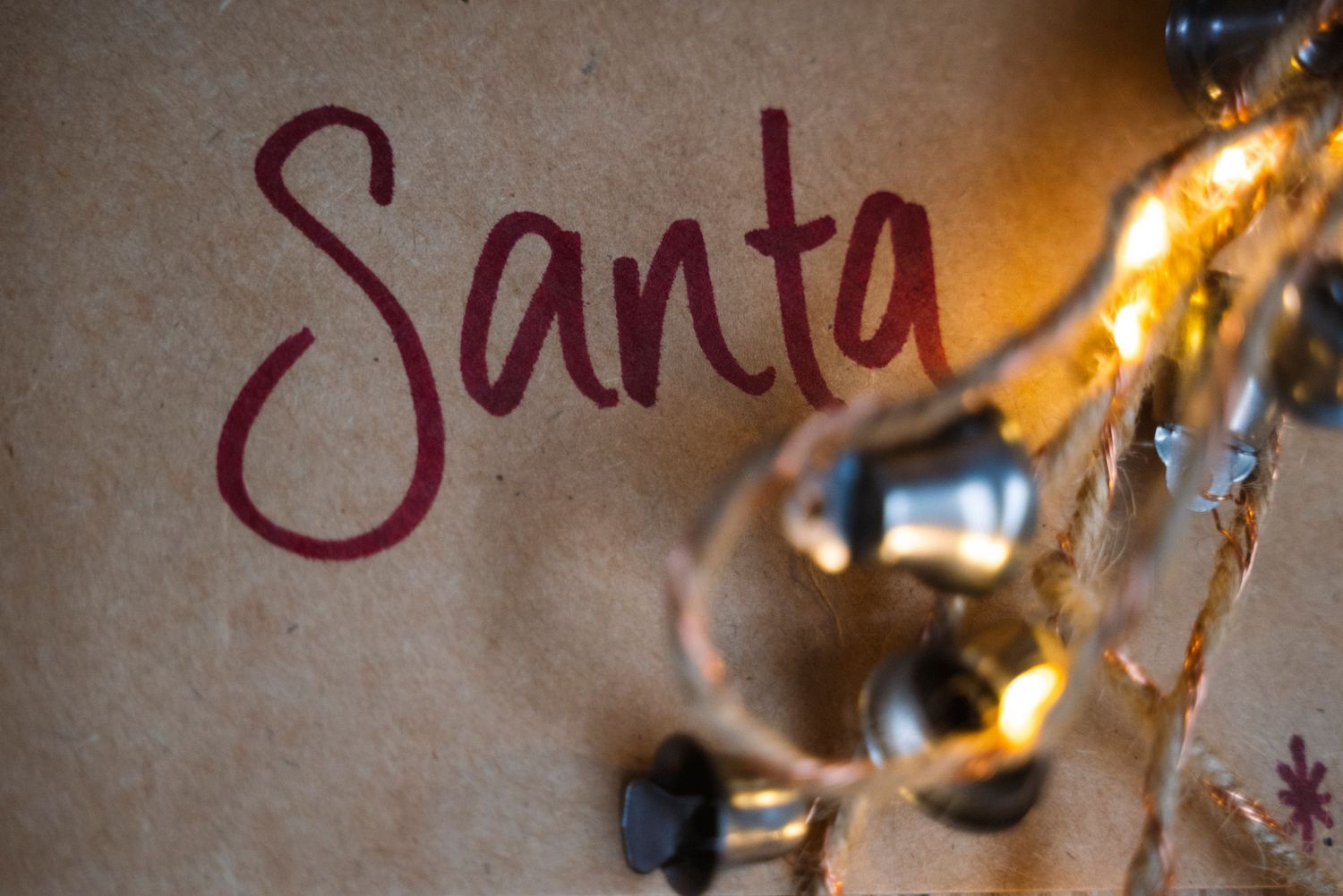 Close-up photograph showing metallic script text with burgundy highlights against a light textured background.