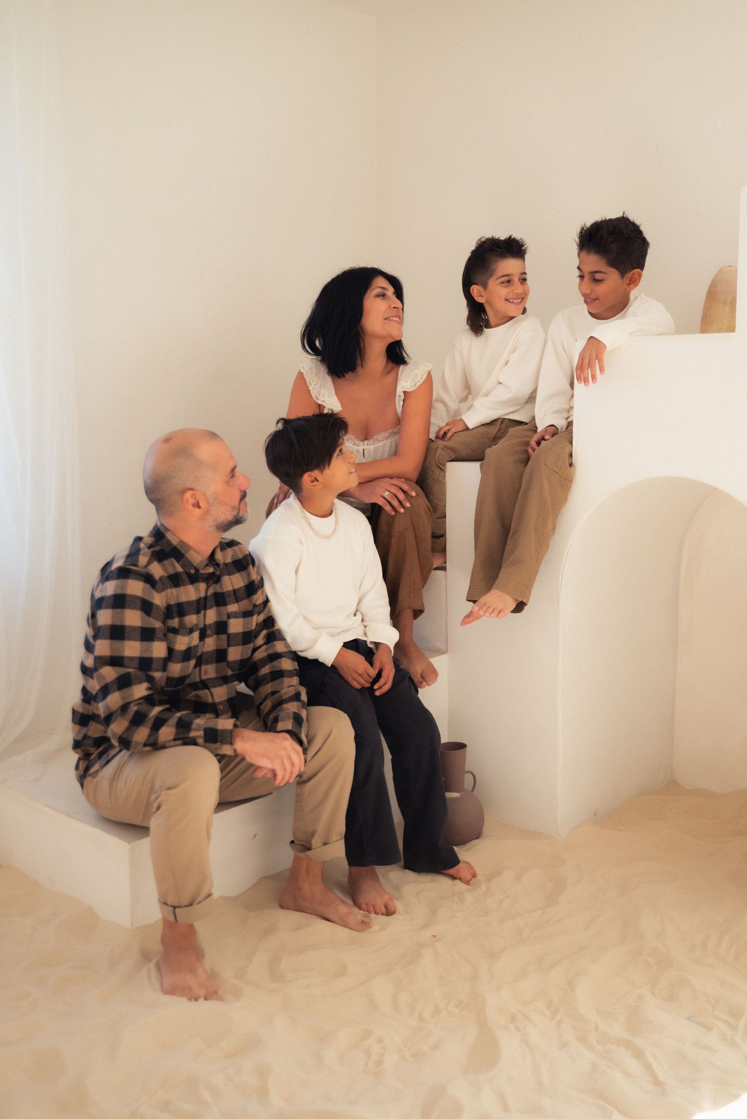 A sequence of photos showing people sitting and interacting in a minimalist white room with beige flooring.