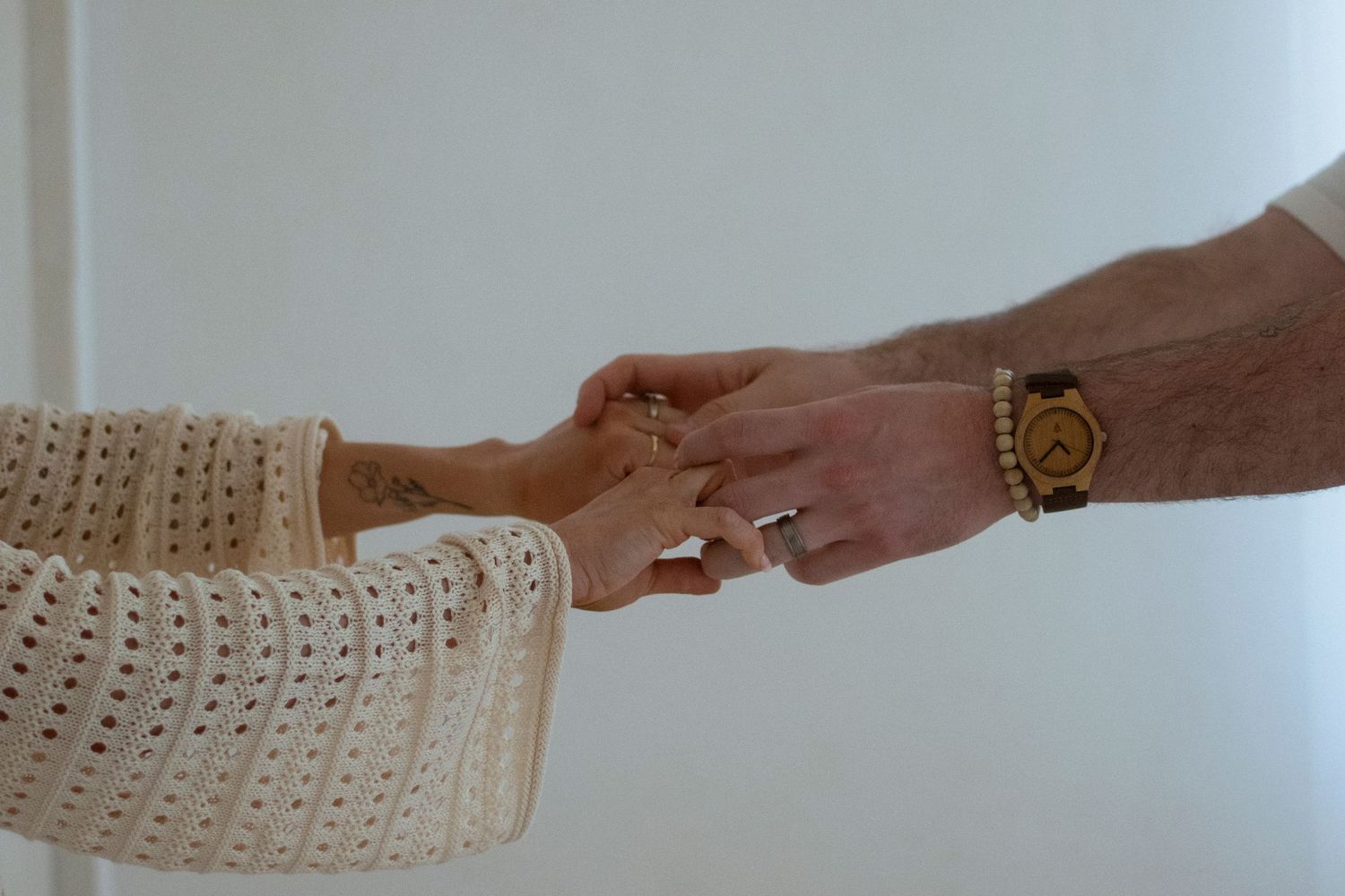 Close up of two hands touching gently against white background.