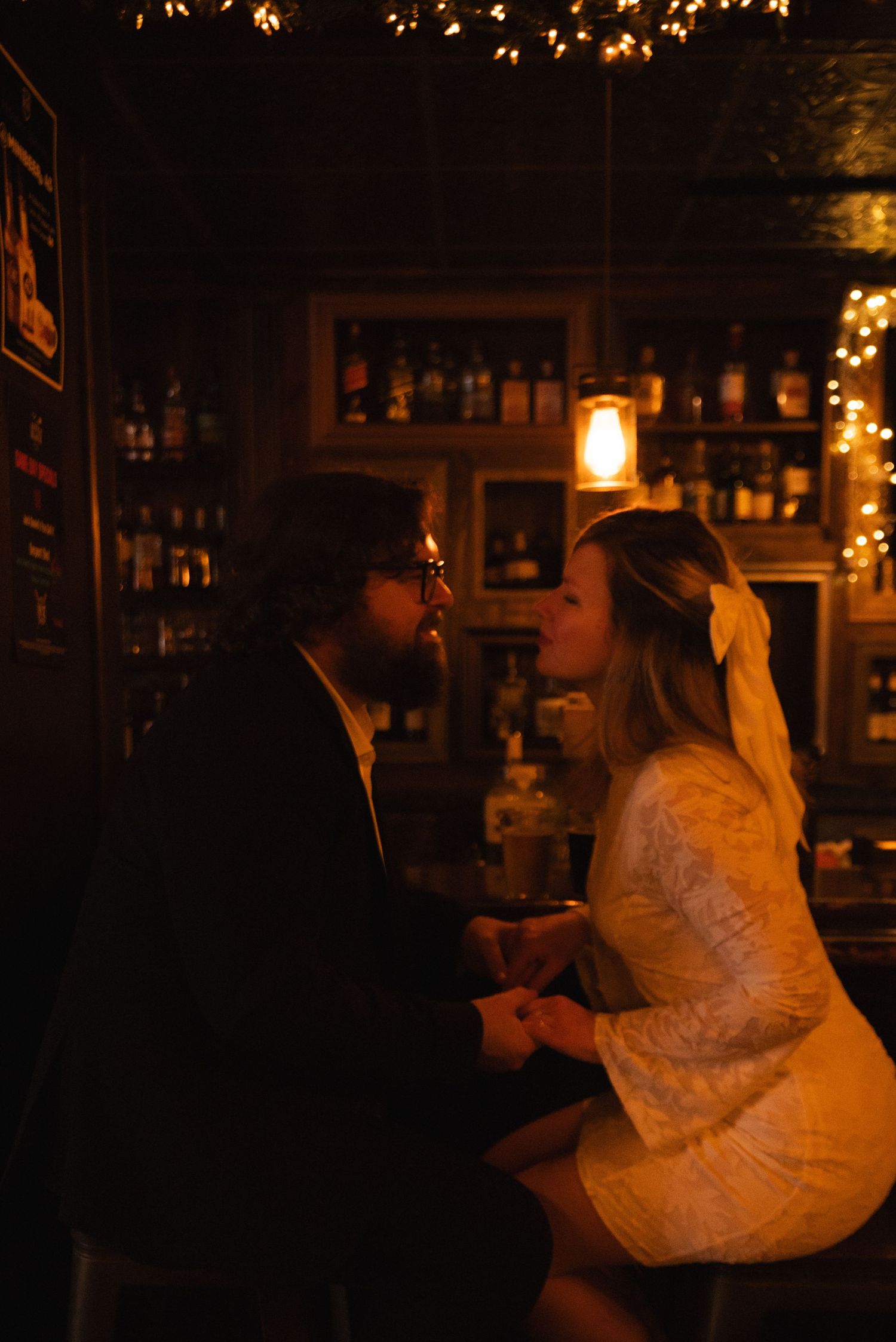 A romantic candlelit scene with a couple in formal attire sharing an intimate moment in warm lighting.