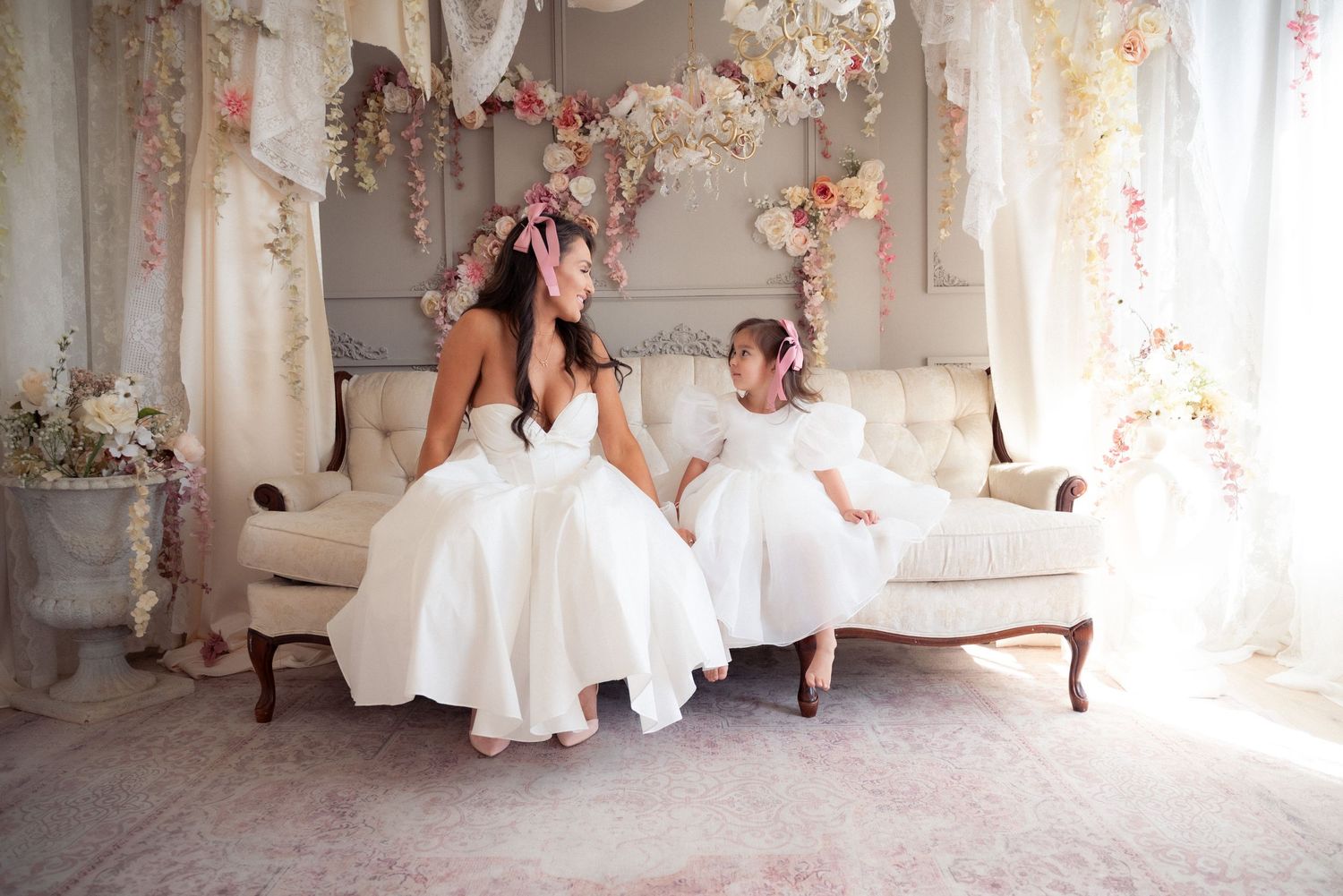 A romantic wedding scene in a luxurious white room with elegant vintage furniture and soft pink floral decorations.