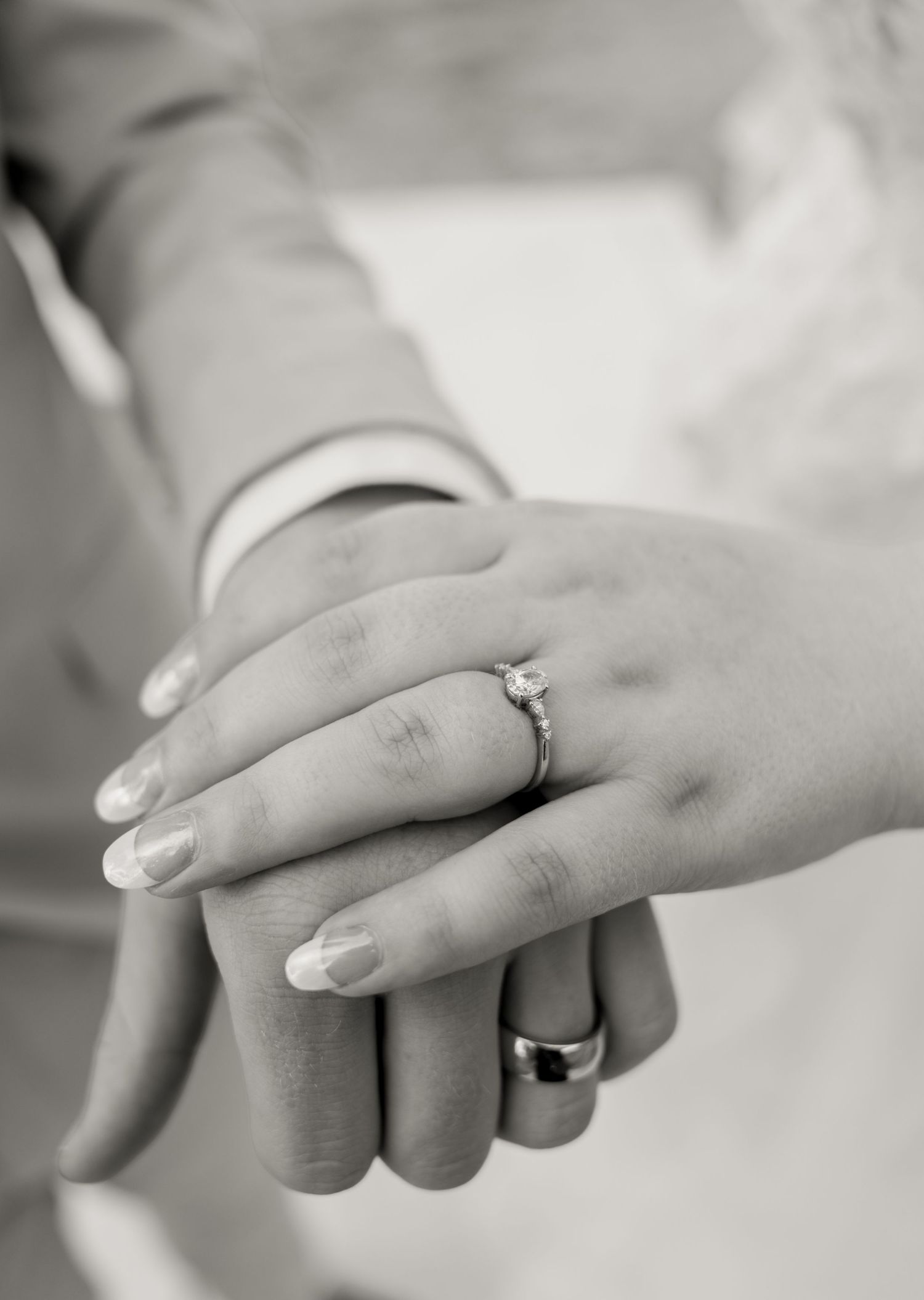 Close-up black and white photo of newlyweds hands showing diamond engagement ring and wedding bands. Oklahoma wedding photographer.