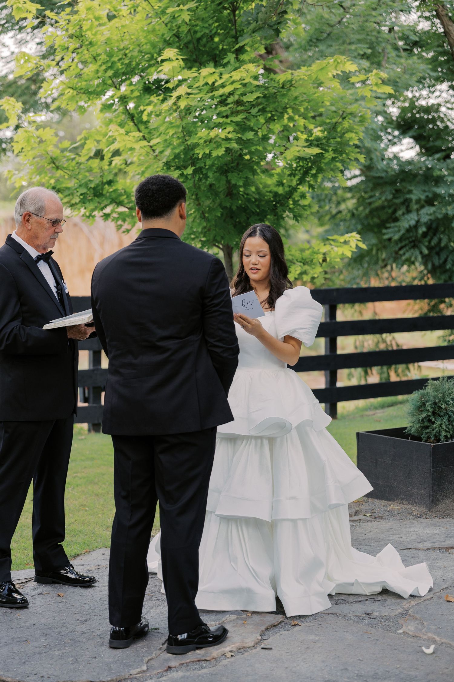 Bride reading her vows to the groom during an outdoor wedding ceremony at Sorelle at Meadow Creek in Oklahoma.