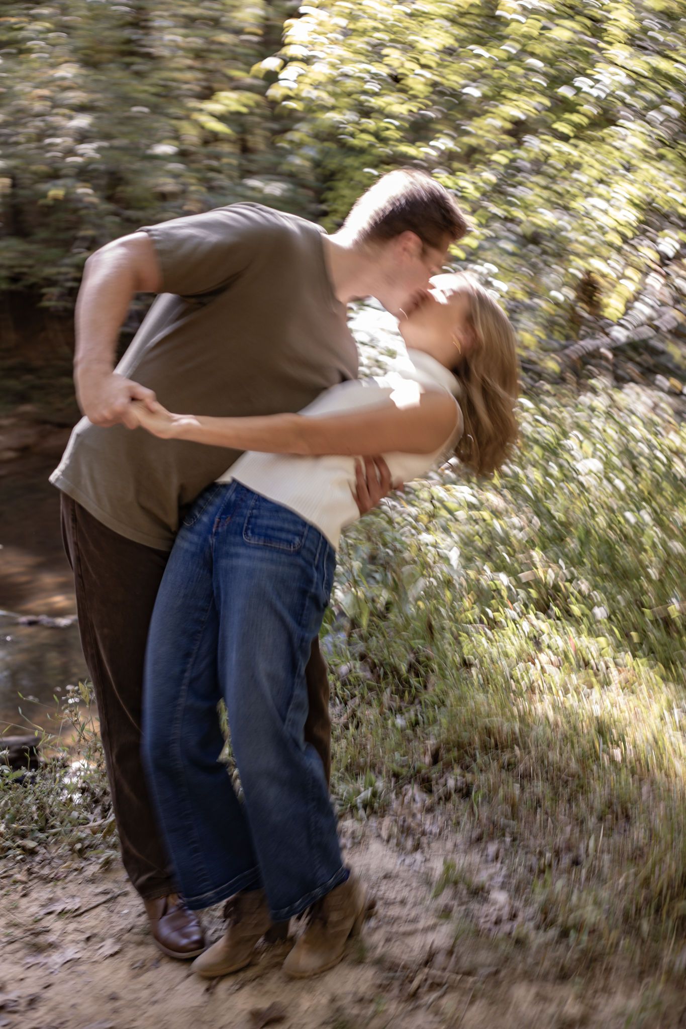 A couple sharing a romantic dance pose in a sunlit outdoor setting.