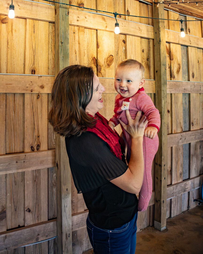 A series of four photos showing a tender interaction between two people in a rustic wooden barn setting.