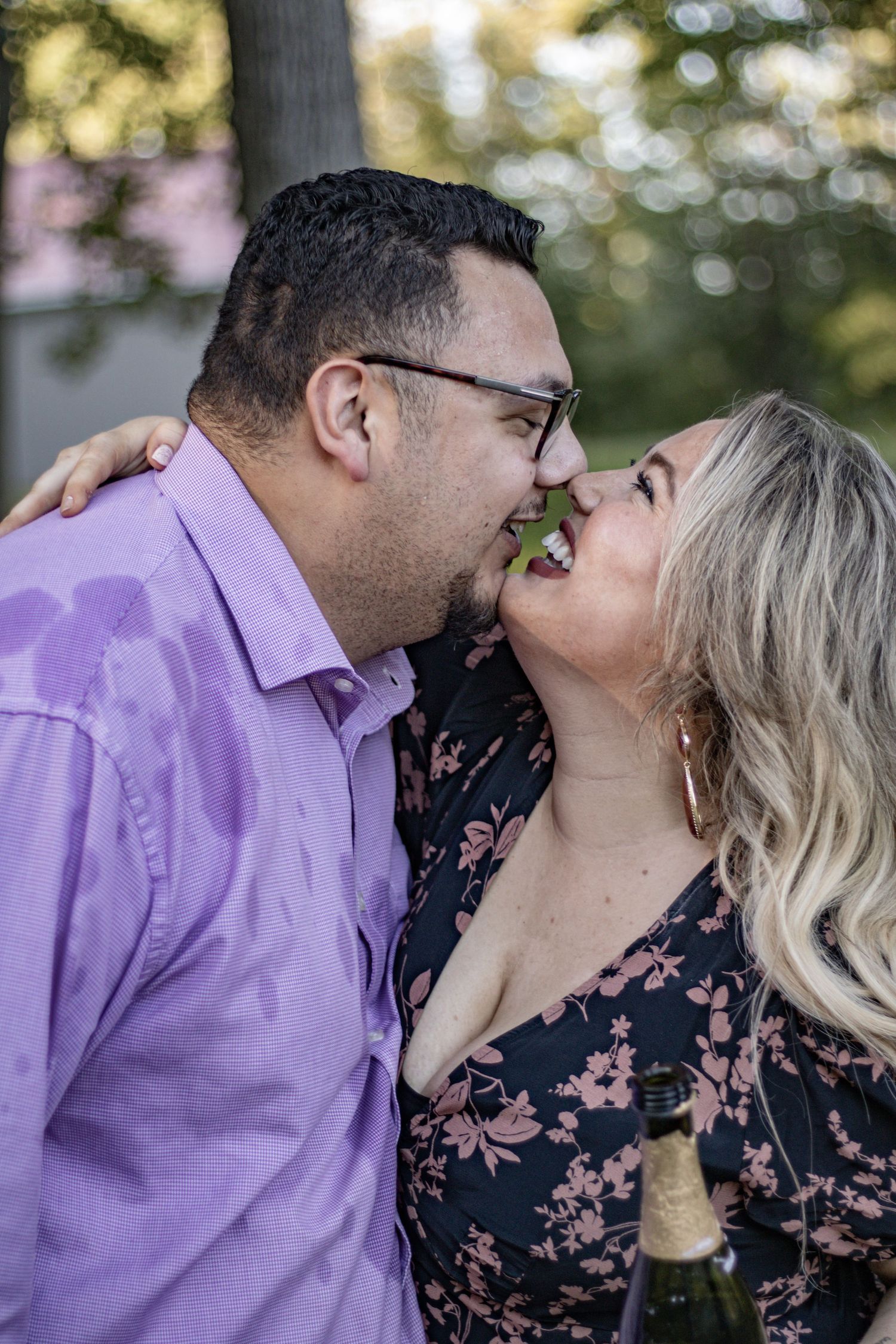 A couple shares a close intimate moment outdoors during golden hour.