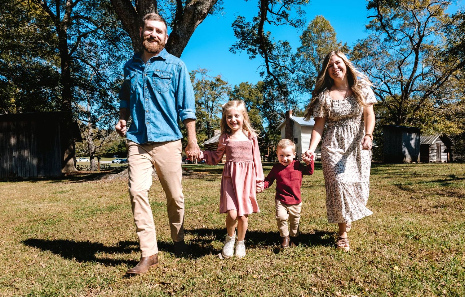Family walking together outdoors on sunny autumn day.