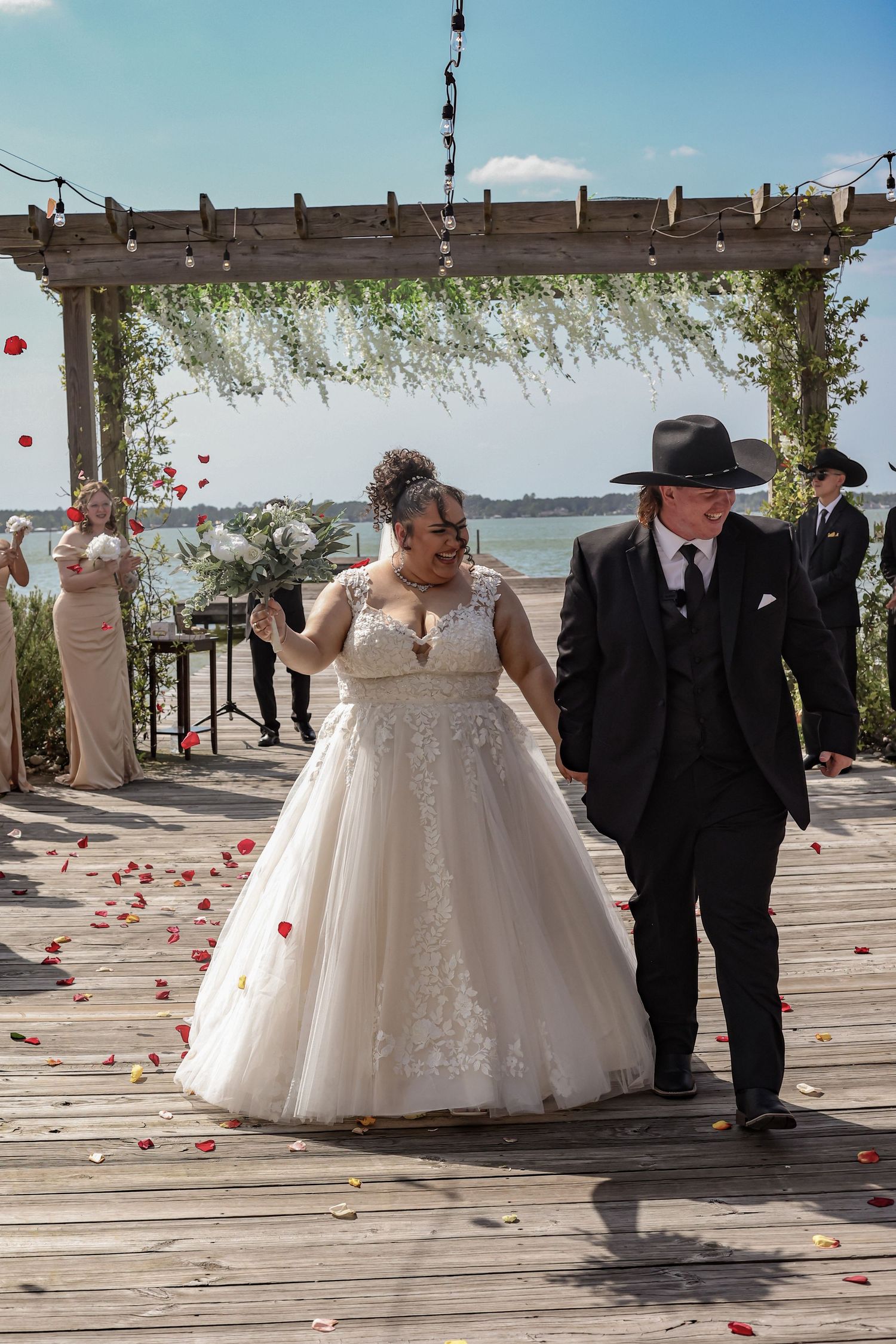 Romantic wedding ceremony on wooden pier overlooking waterfront.