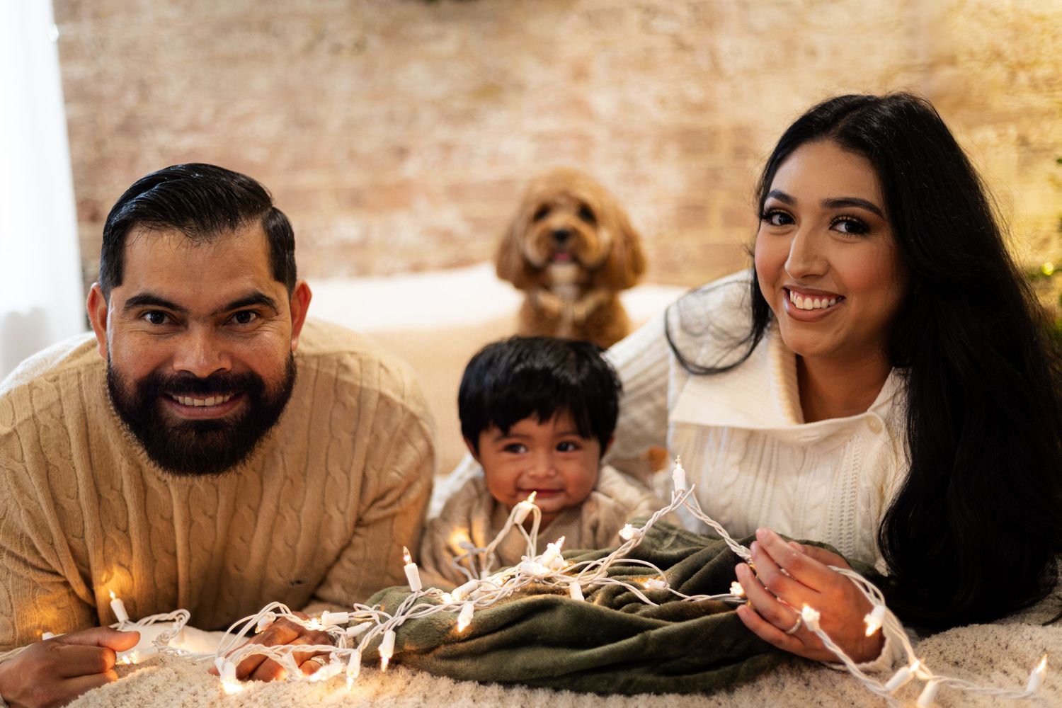 Family of three celebrating with cake and birthday candles with their dog.