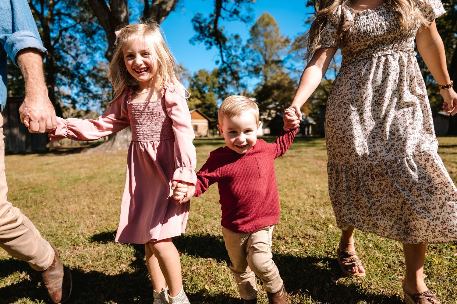 Close-up of family holding hands while walking in park.