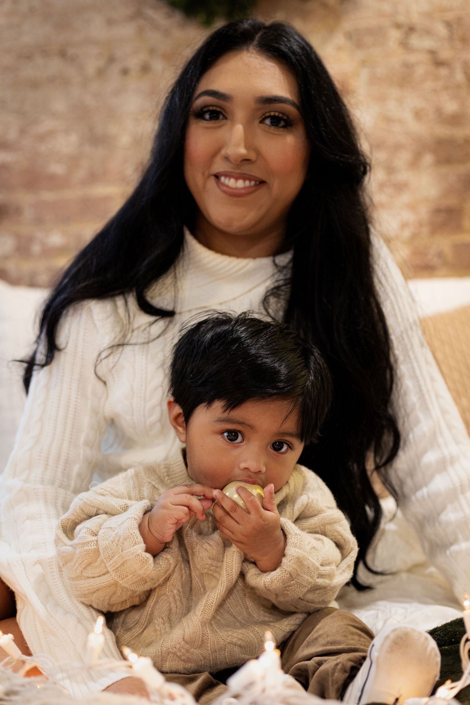 Mother and child in matching cream sweaters sharing tender moment.