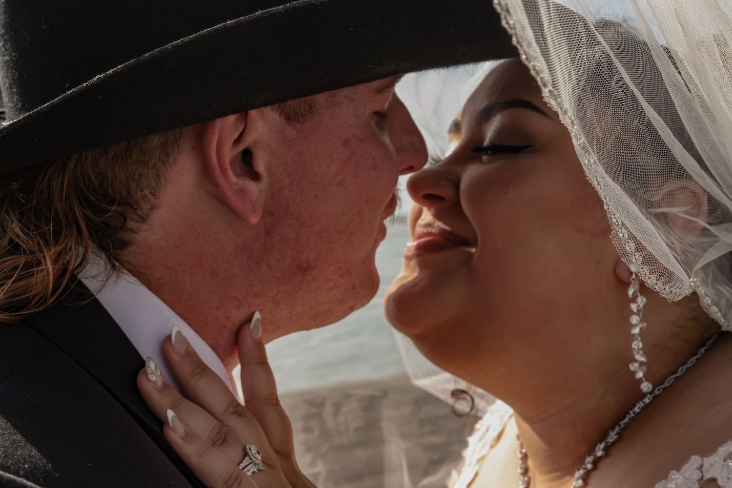 Intimate wedding couple moment captured on scenic waterfront dock.